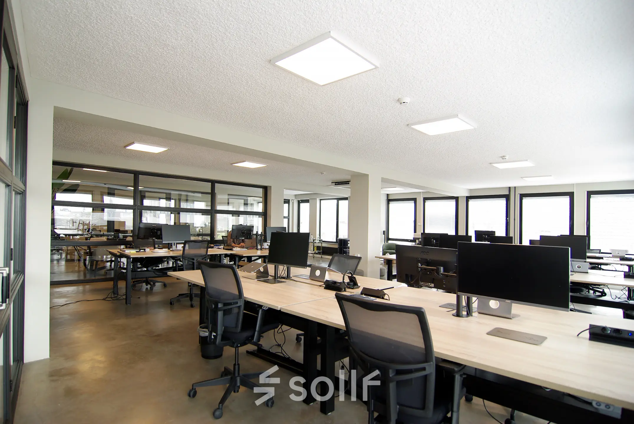 Ruime kantoorruimte te huur op Kleine Gartmanplantsoen 21 in Amsterdam Centrum, met diverse bureaus en computerschermen. Ideaal voor flexibele werkplekken in een modern kantoorpand. Natuurlijk licht en strakke inrichting.