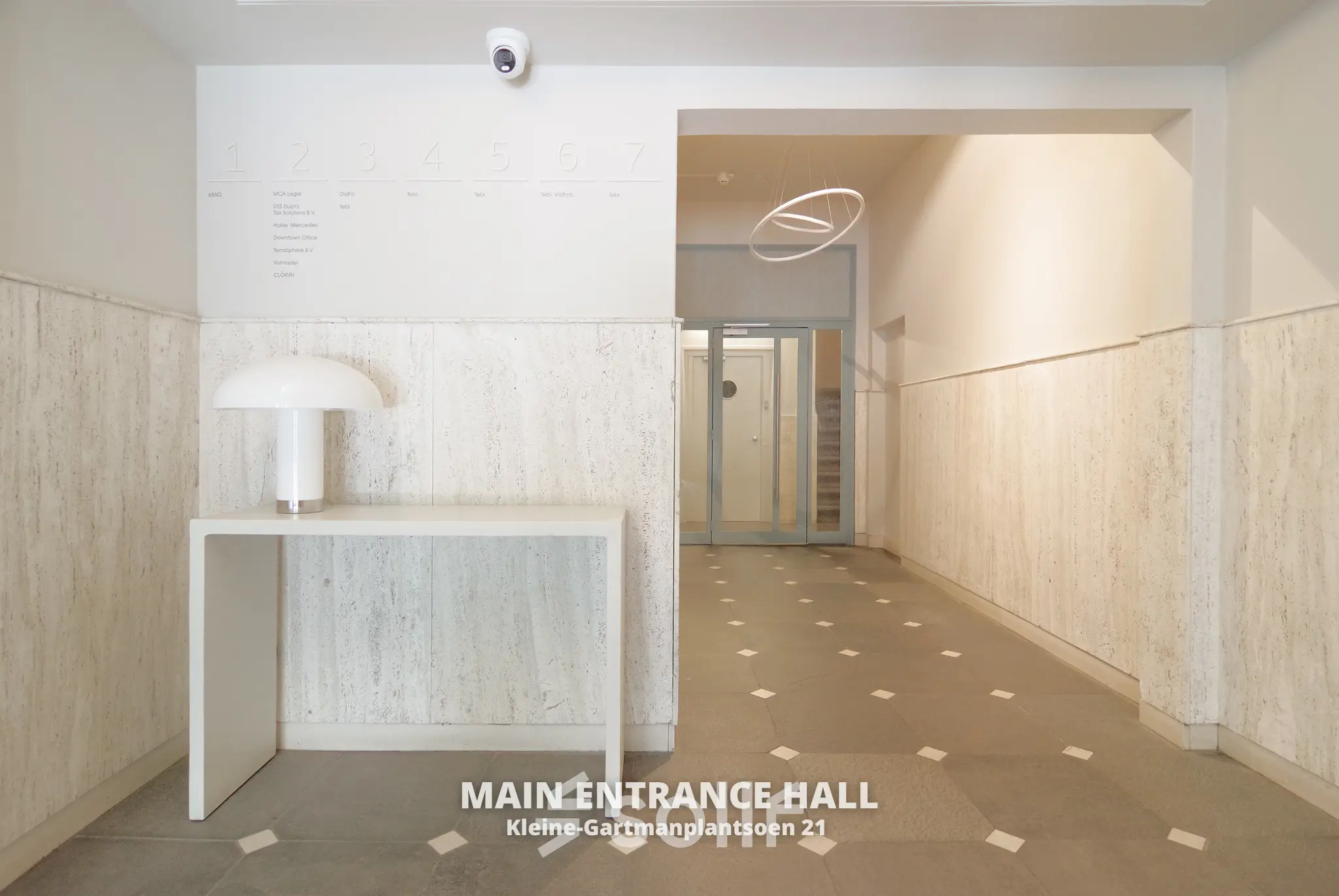 Ingang van een kantoorpand op Kleine Gartmanplantsoen 21 in Amsterdam Centrum. Stijlvolle entree met strakke muren en moderne decoratie. Geschikt voor bedrijven die kantoorruimte willen huren.