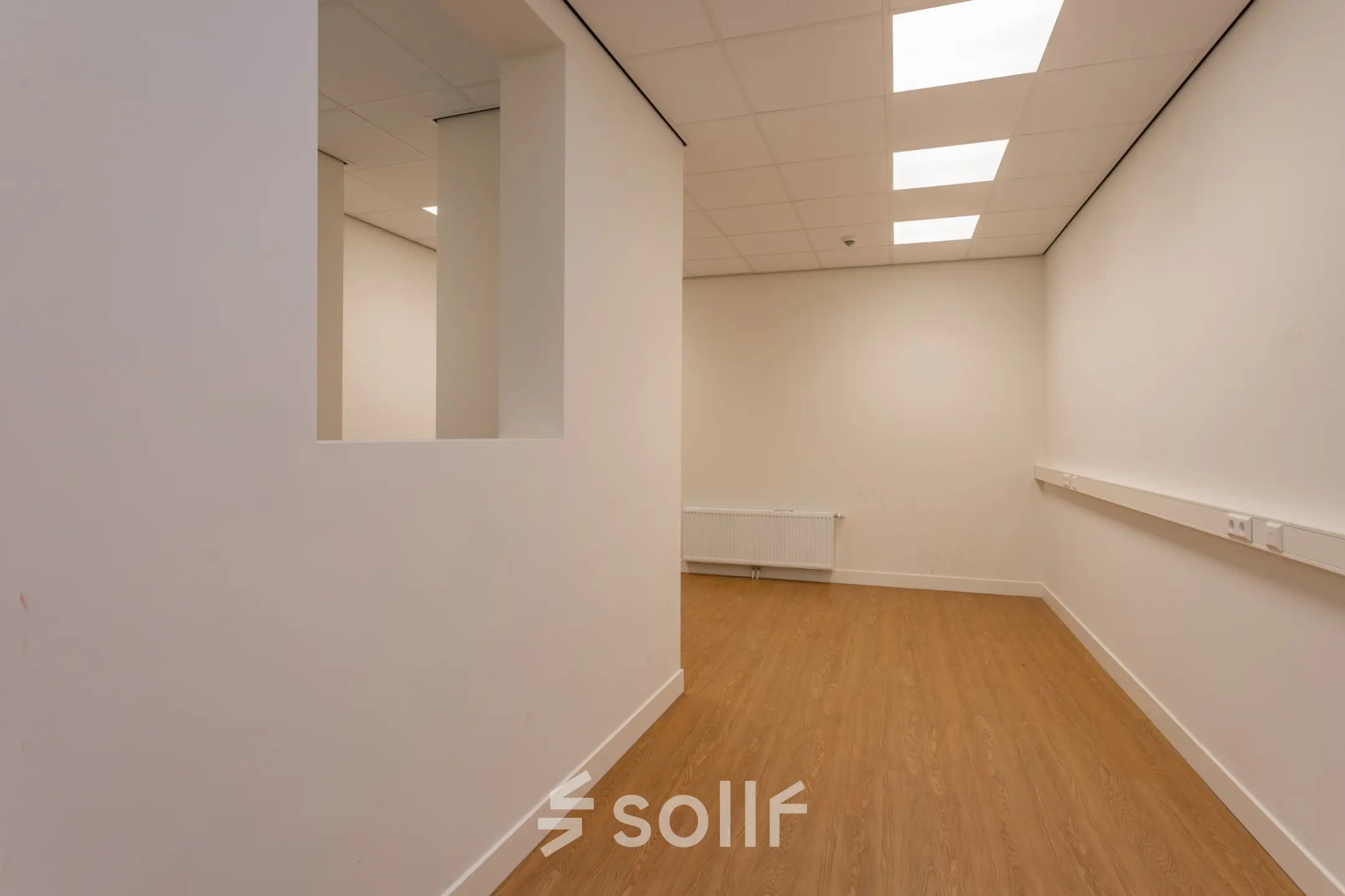 Lichte kantoorruimte met houten vloer en witte muren in Amsterdam Centrum, klaar voor huur. Gelegen op Korte Leidsedwarsstraat 133A 133A, geschikt voor diverse kantooractiviteiten.