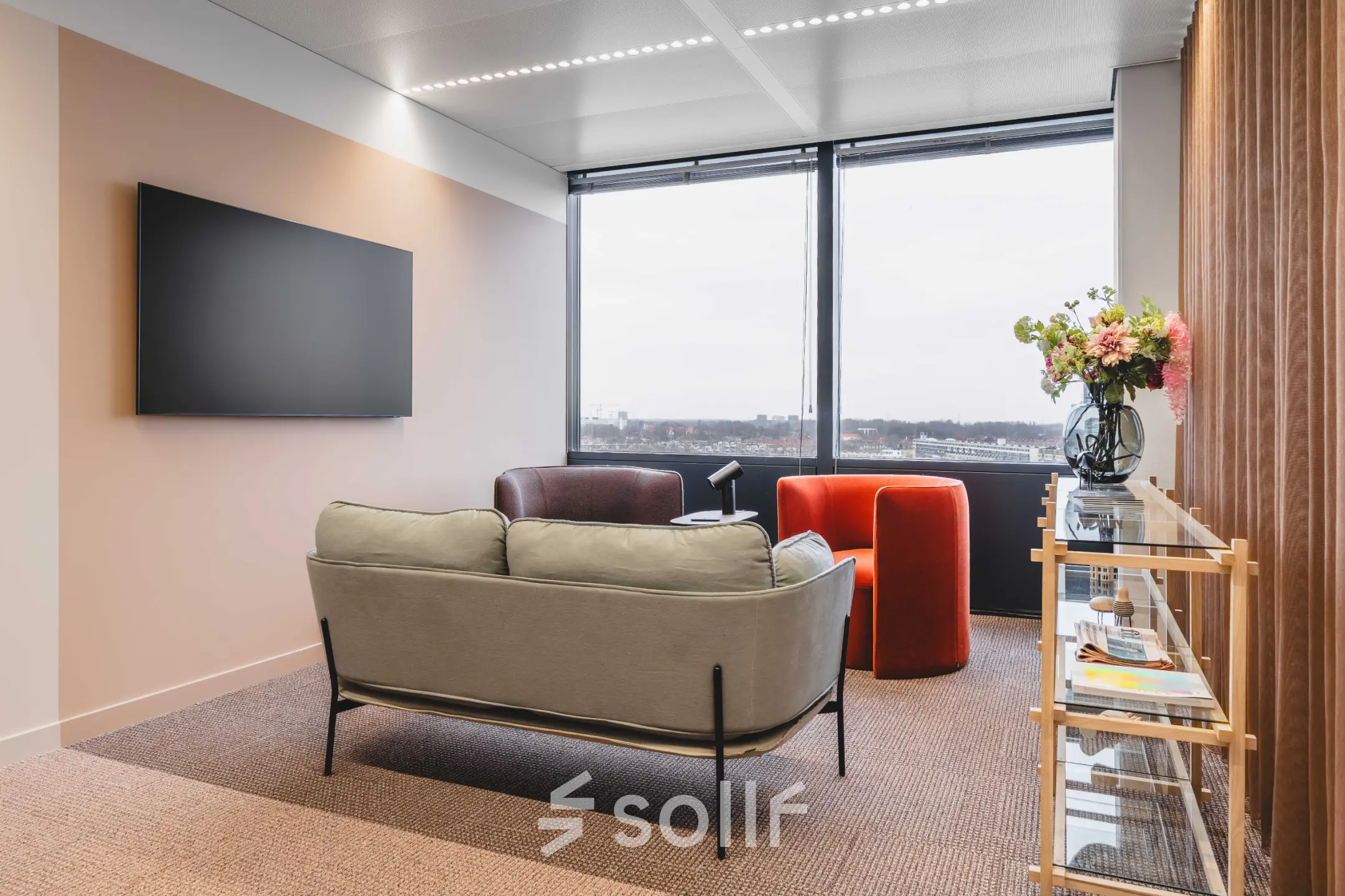 Moderne kantoorruimte huren aan de Piet Heinkade 55 in Amsterdam Centrum, met comfortabele zitbank, fauteuil en grote ramen die uitzicht bieden op de stad.