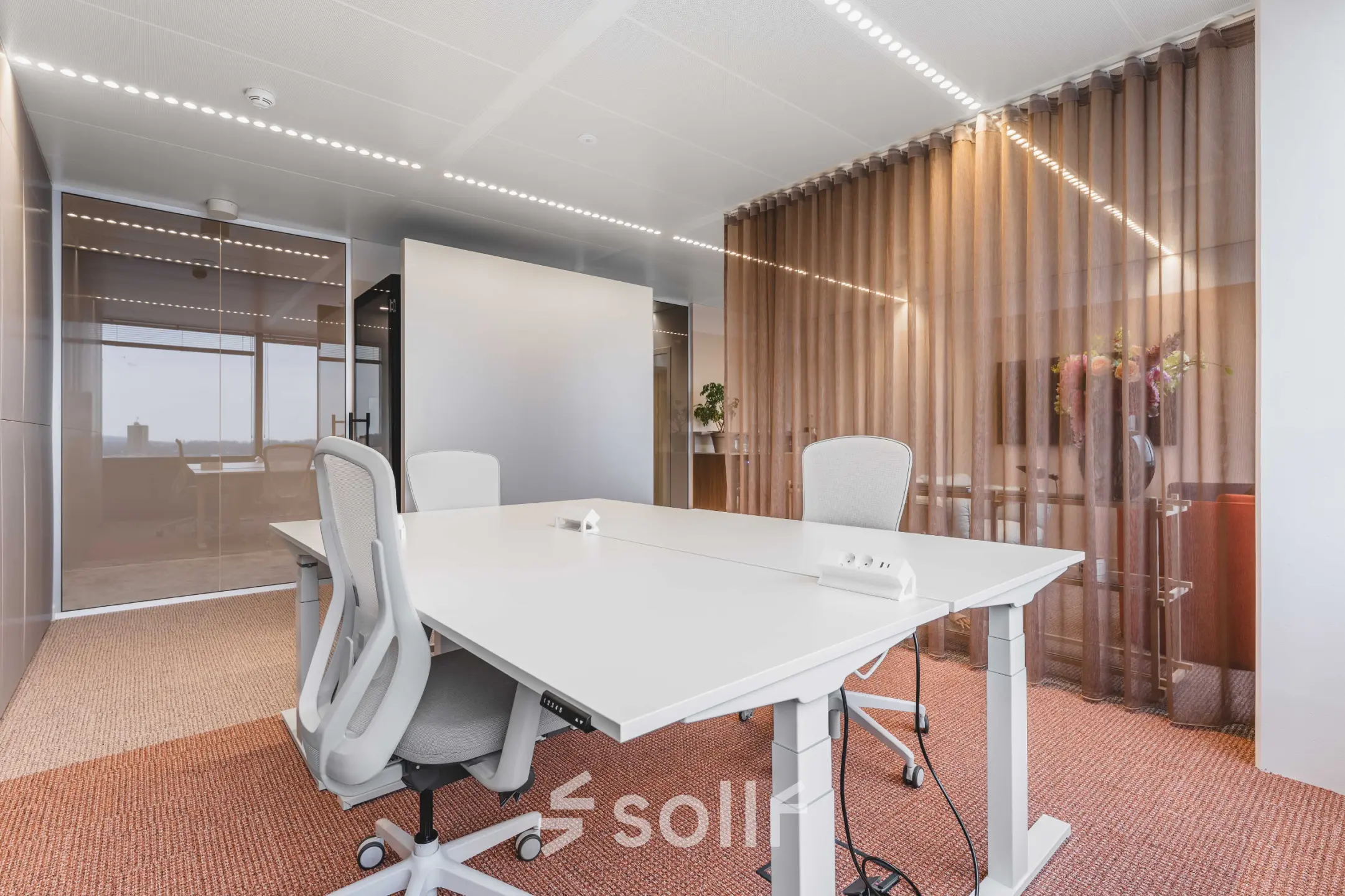 Moderne kantoorruimte voor verhuur in Amsterdam Centrum aan Piet Heinkade 55, met witte bureaus, ergonomische stoelen en glazen wanden, ideaal voor zakelijke ontmoetingen.
