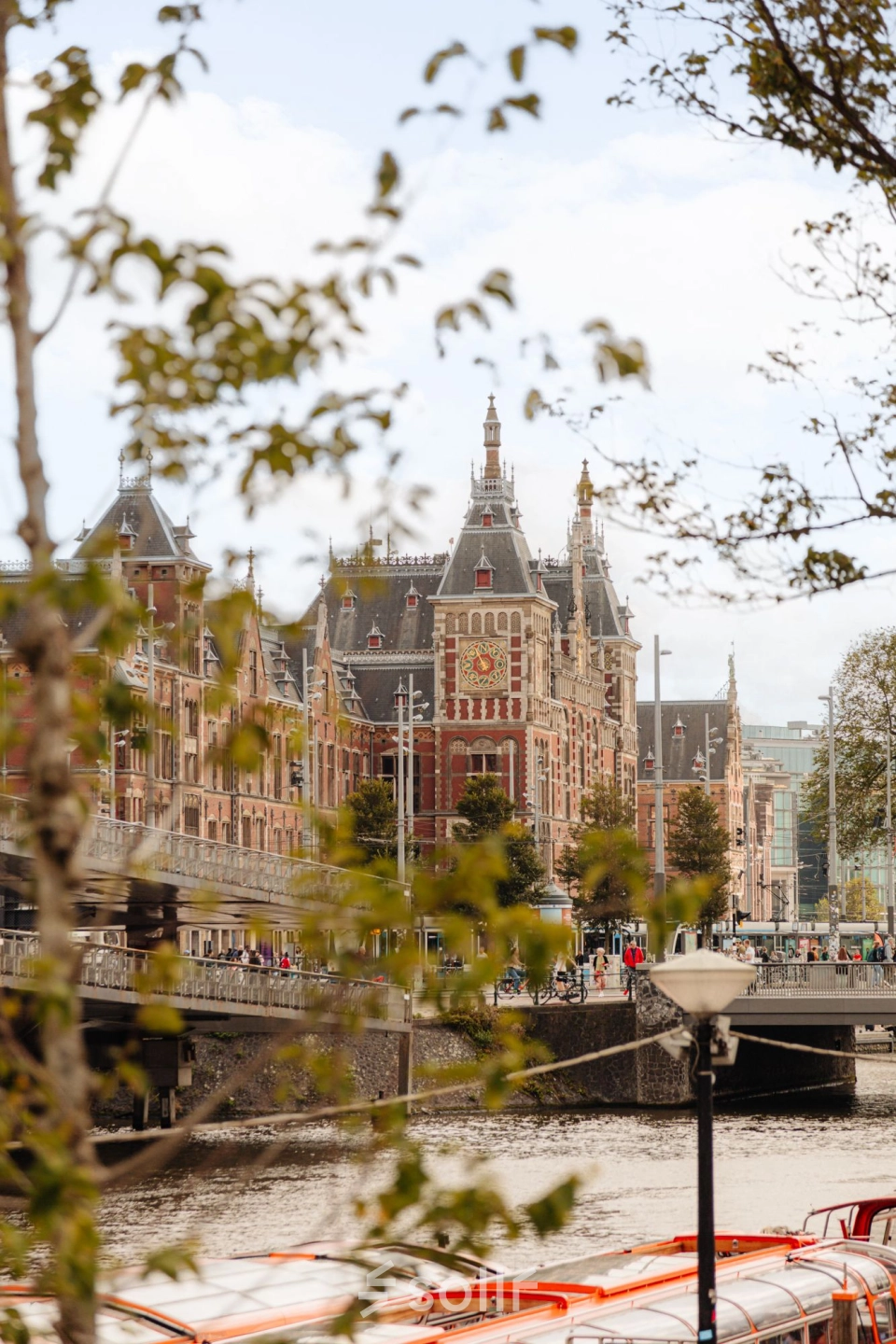 Uitzicht op een historisch kantoorpand aan de Prins Hendrikkade 14 in Amsterdam Centrum, gelegen aan het water met architectonische details.