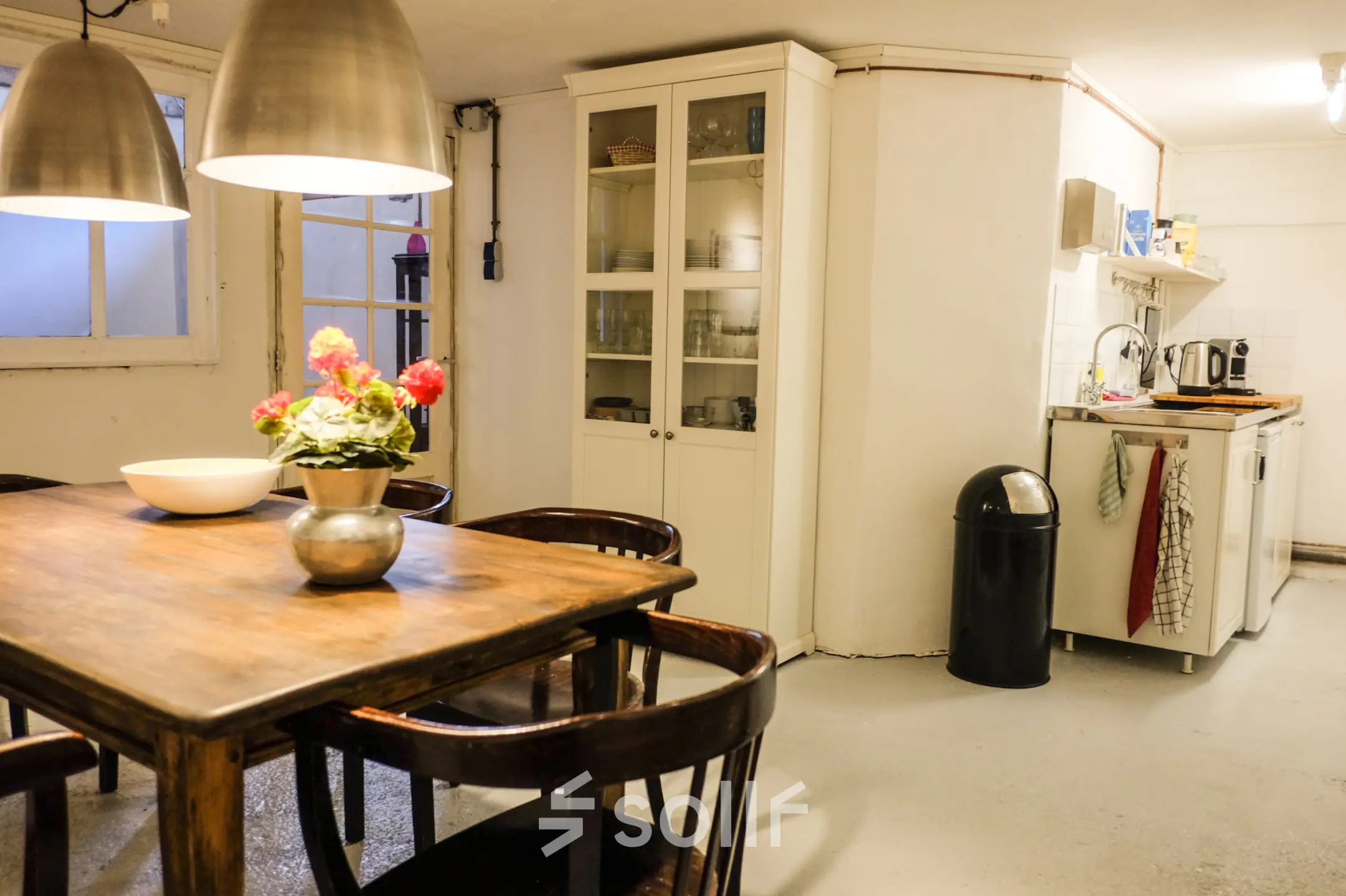 Gezellige kantoorruimte met houten tafel, stoelen en een keukentje op Prinseneiland 23A, Amsterdam Centrum. Ideaal voor kantoorruimte huren met een huiselijke sfeer.