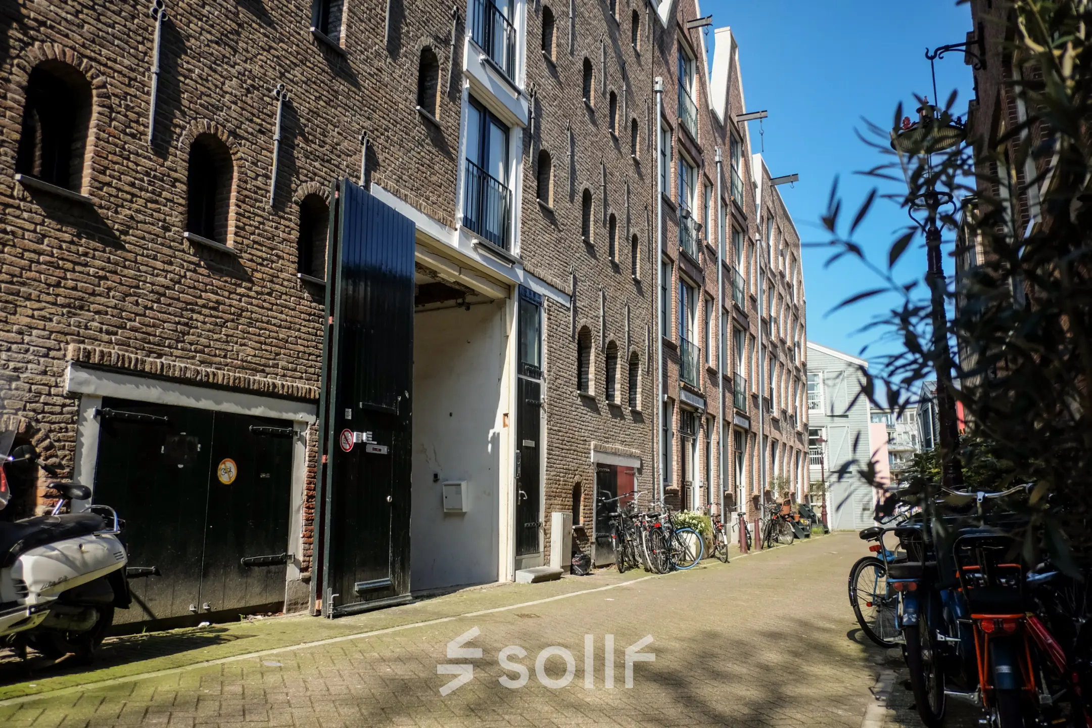 Kantoorpand aan Prinseneiland 23A in Amsterdam Centrum, gezien vanaf de straat met historische bakstenen gevels en geparkeerde fietsen.