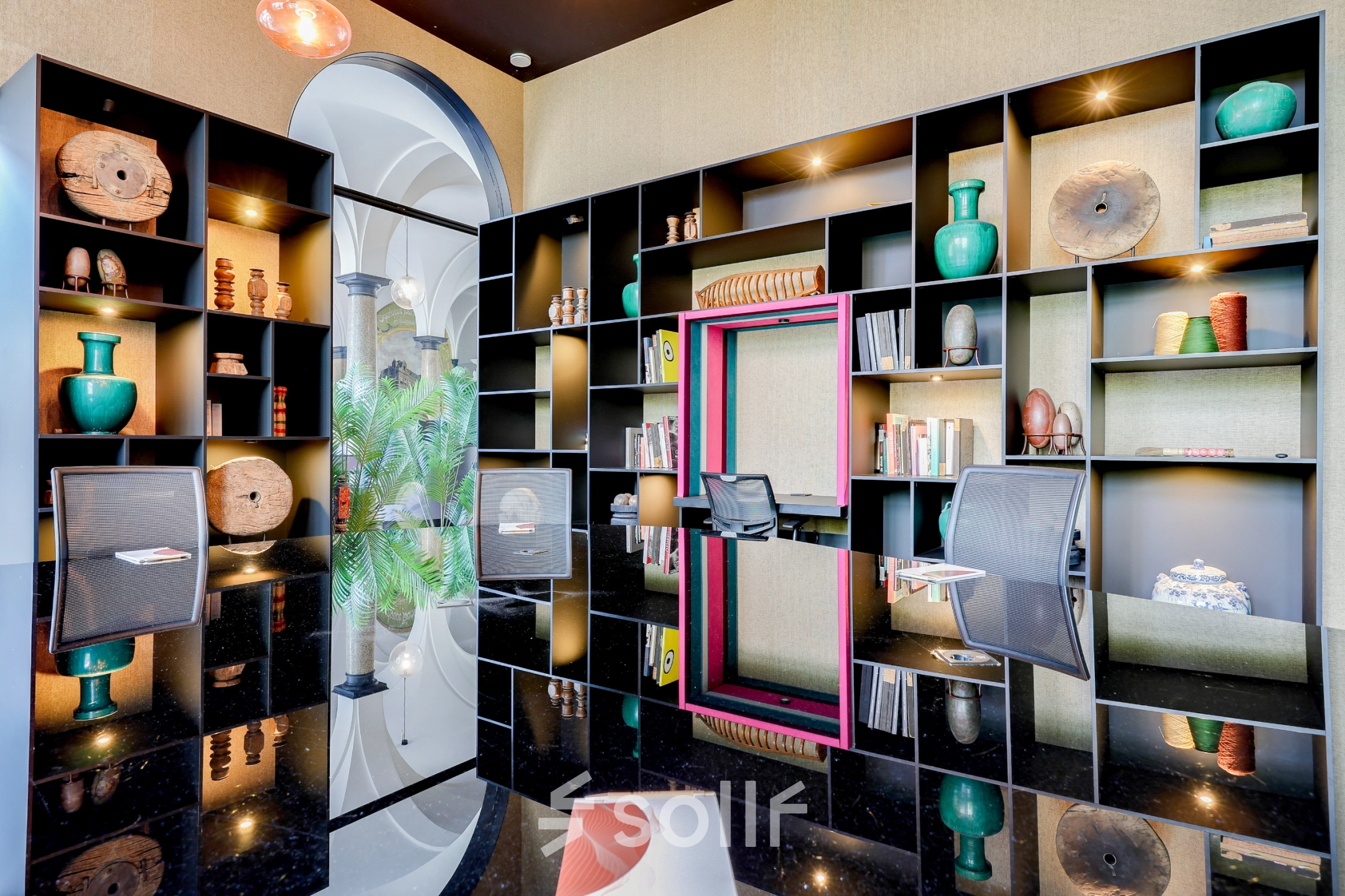 Moderne kantoorruimte huren in Amsterdam Centrum met stijlvolle inrichting, inclusief luxe bureau en designstoel. De kastenwand is gevuld met decoratie en biedt voldoende opbergruimte.