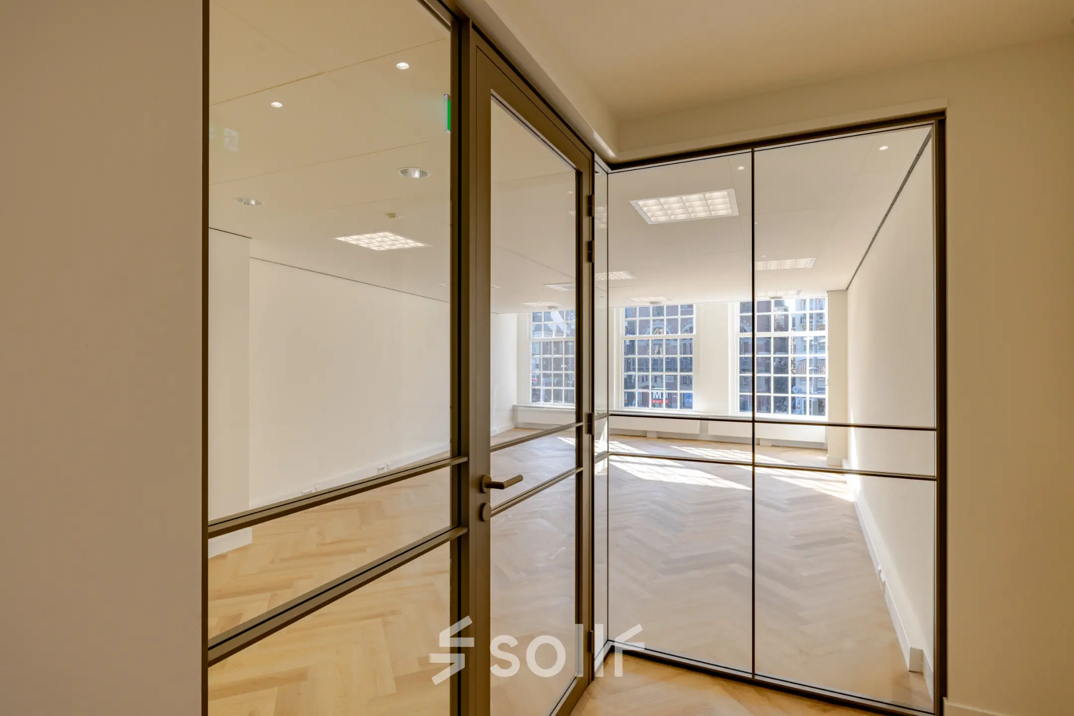 Lichte, open kantoorruimte in het kantoorpand op Rokin 117 117, Amsterdam Centrum, met houten vloer en grote ramen voor veel natuurlijk licht.