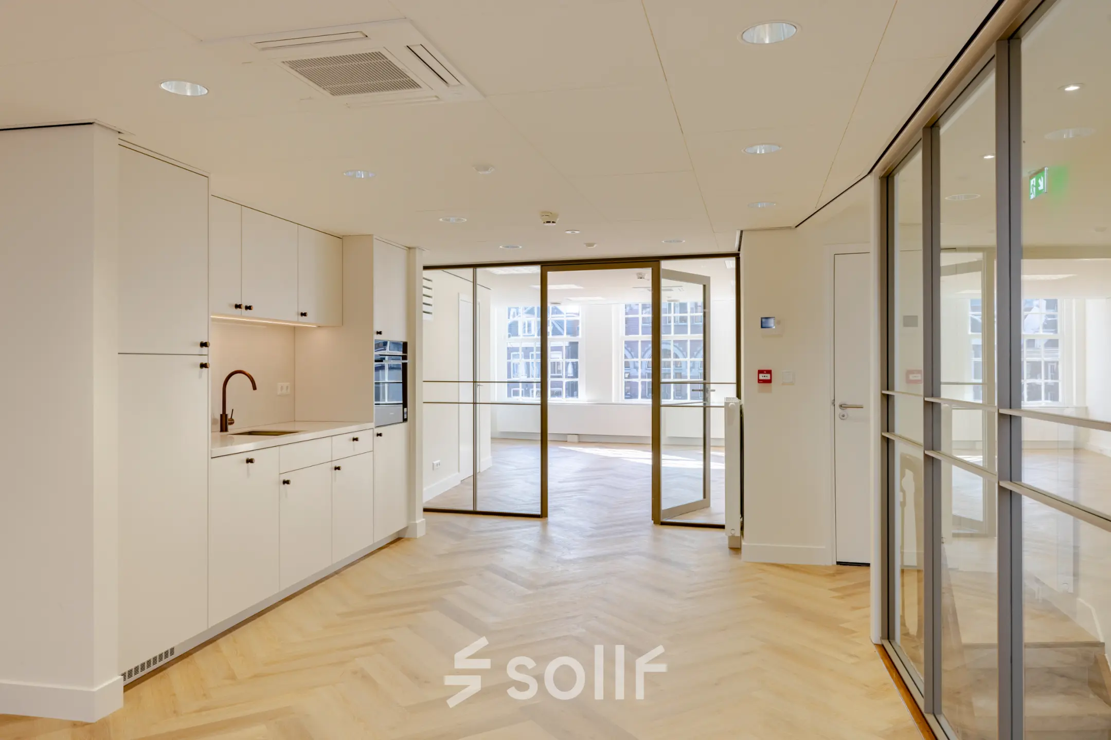 Lichte en moderne kantoorruimte op Rokin 117 117 Amsterdam Centrum met houten vloer, glazen scheidingswanden en een kleine pantry. Ideaal voor wie een kantoorpand wil huren.