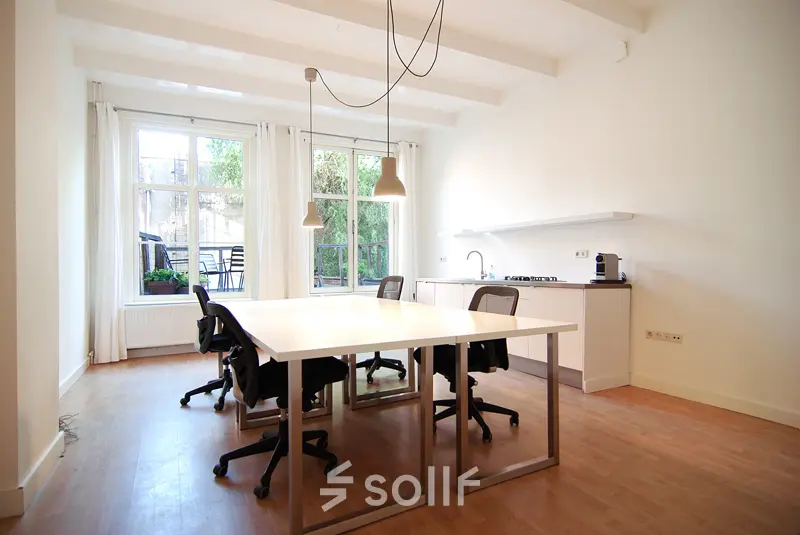 Lichte kantoorruimte huren op Warmoesstraat 155, Amsterdam Centrum, met ruime tafels en een keukenhoek voor een efficiënte werkomgeving.