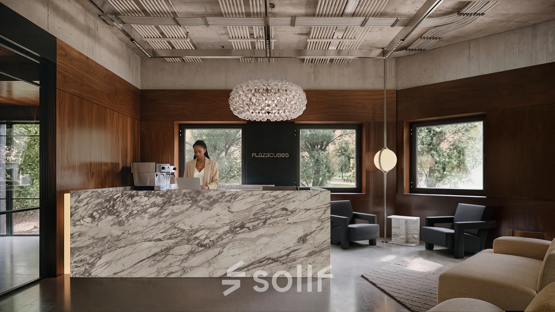 Moderne receptieruimte in kantoorpand op Weteringschans 126, Amsterdam Centrum, met design interieur en marmeren balie. Persoon bezig achter laptop bij de receptie.