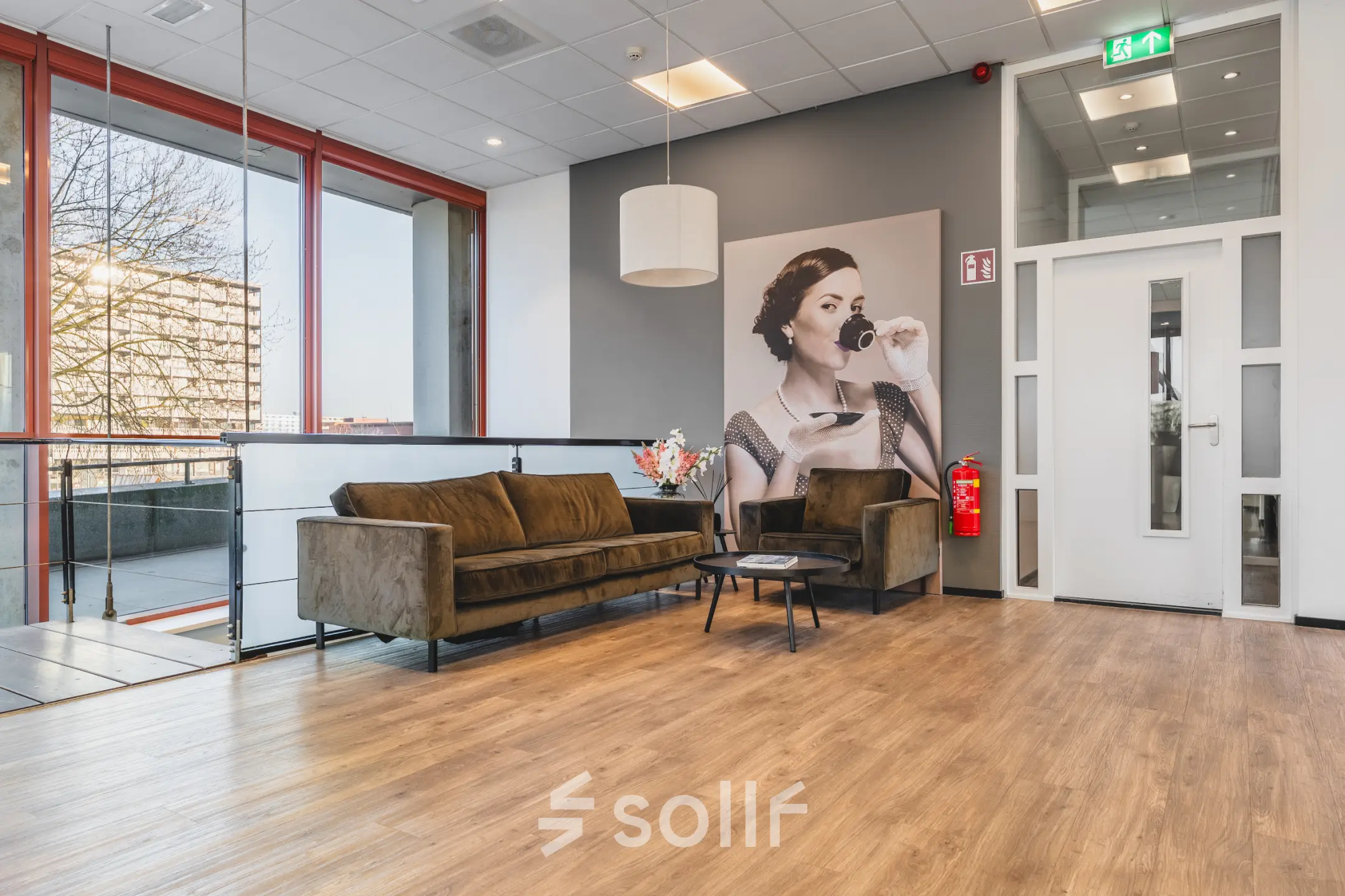 Stijlvolle kantoorruimte huren op Daalwijkdreef 47 in Amsterdam Duivendrecht met een moderne loungehoek en een grote afbeelding van een elegante dame aan de muur.