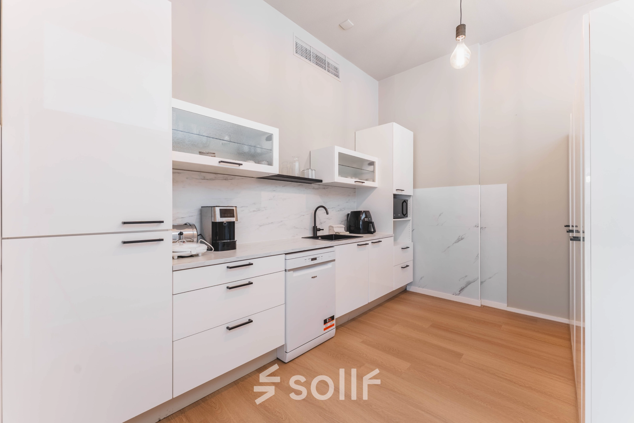 Een lichte pantry in een kantoorpand aan de Herengracht 221, Amsterdam Grachtengordel, met moderne keukenapparatuur en een strakke afwerking.