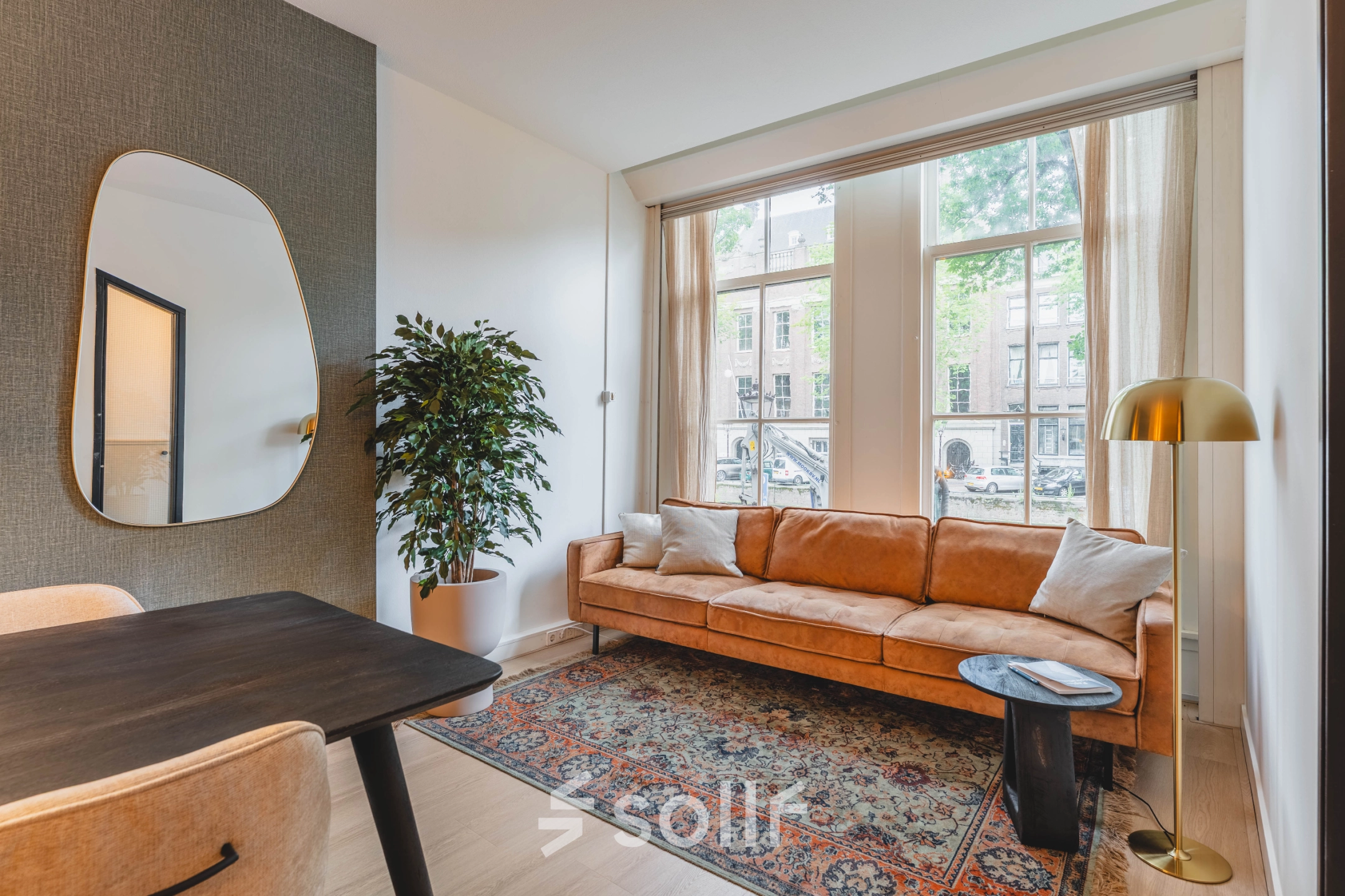 Gezellige kantoorruimte huren op Herengracht 221, Amsterdam Grachtengordel, met een comfortabele bank, een grote spiegel en een stijlvolle inrichting.