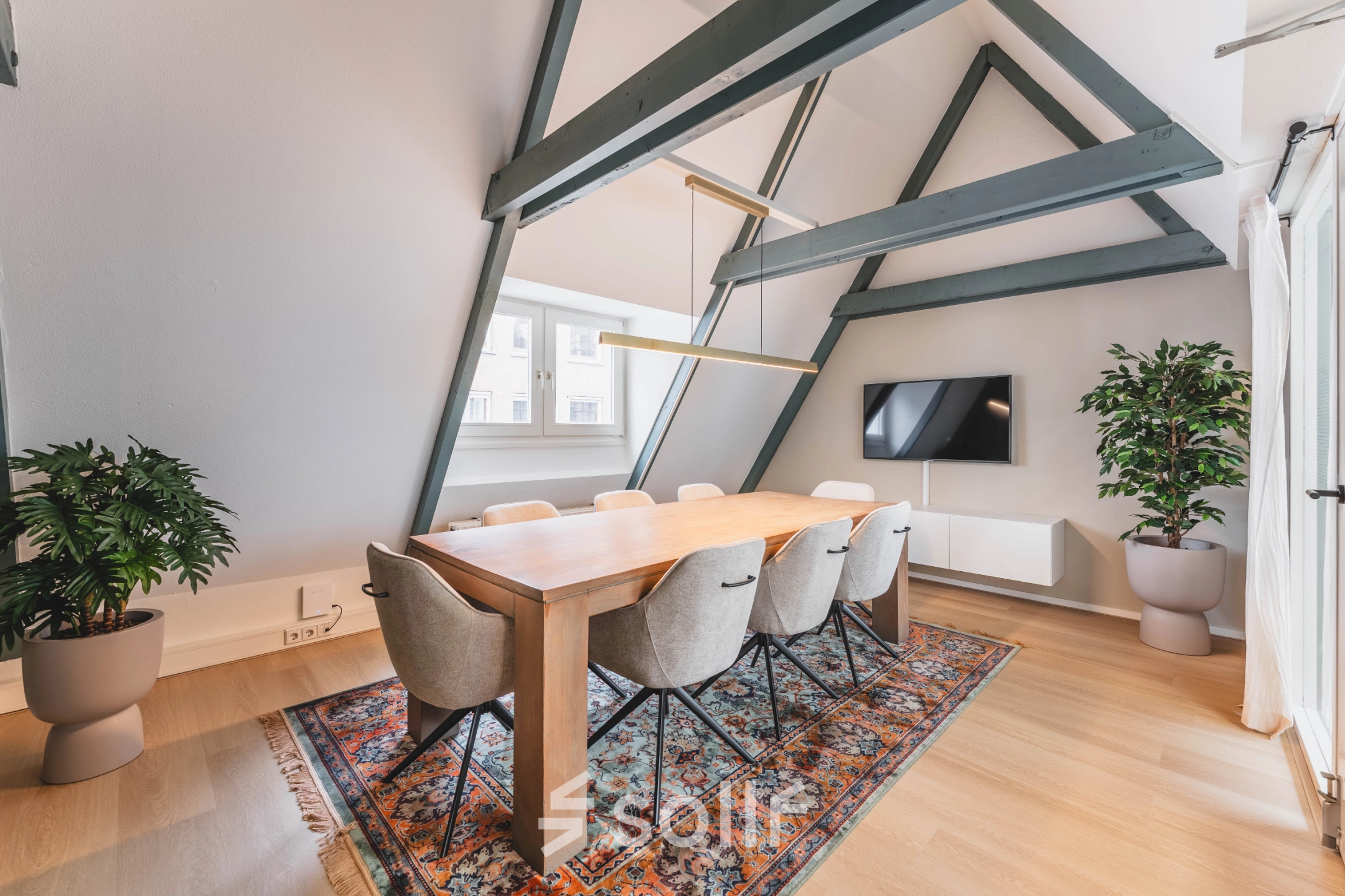 Moderne en lichte vergaderruimte met een lange houten tafel en comfortabele stoelen in een kantoorpand op Herengracht 221, Amsterdam Grachtengordel.