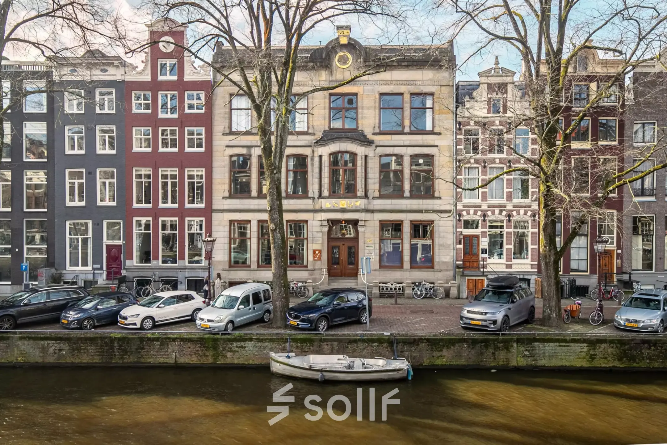 Historisch kantoorpand aan de Herengracht 320 in Amsterdam Grachtengordel, met klassieke gevel aan de gracht, omgeven door geparkeerde auto's en fietsen.
