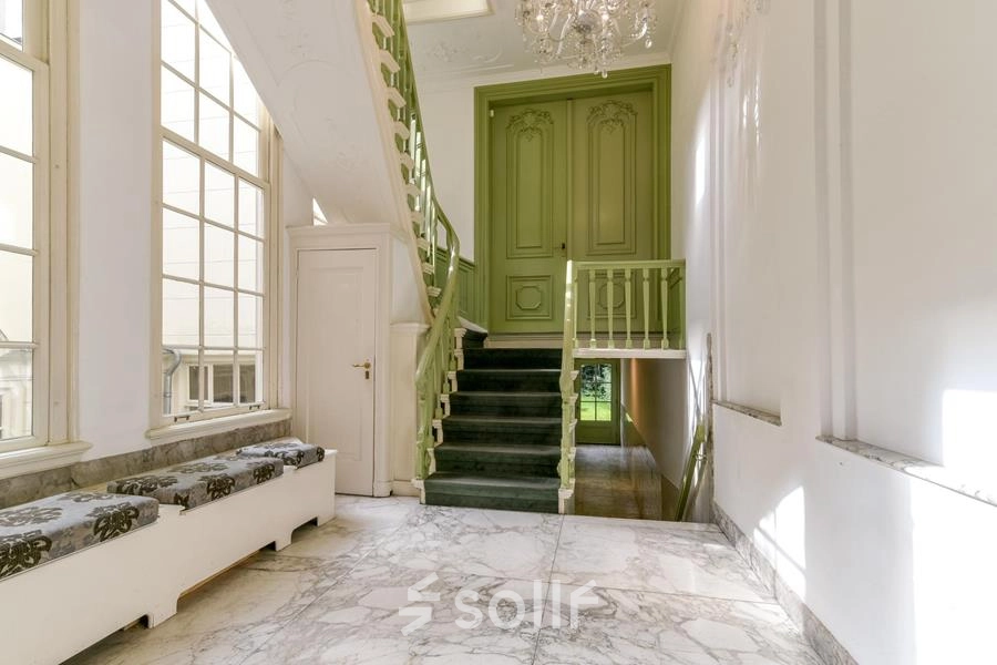 Historisch kantoorpand aan de Herengracht 338 in de Amsterdam Grachtengordel met marmeren vloeren en een decoratieve groene trap, beschikbaar voor huur.