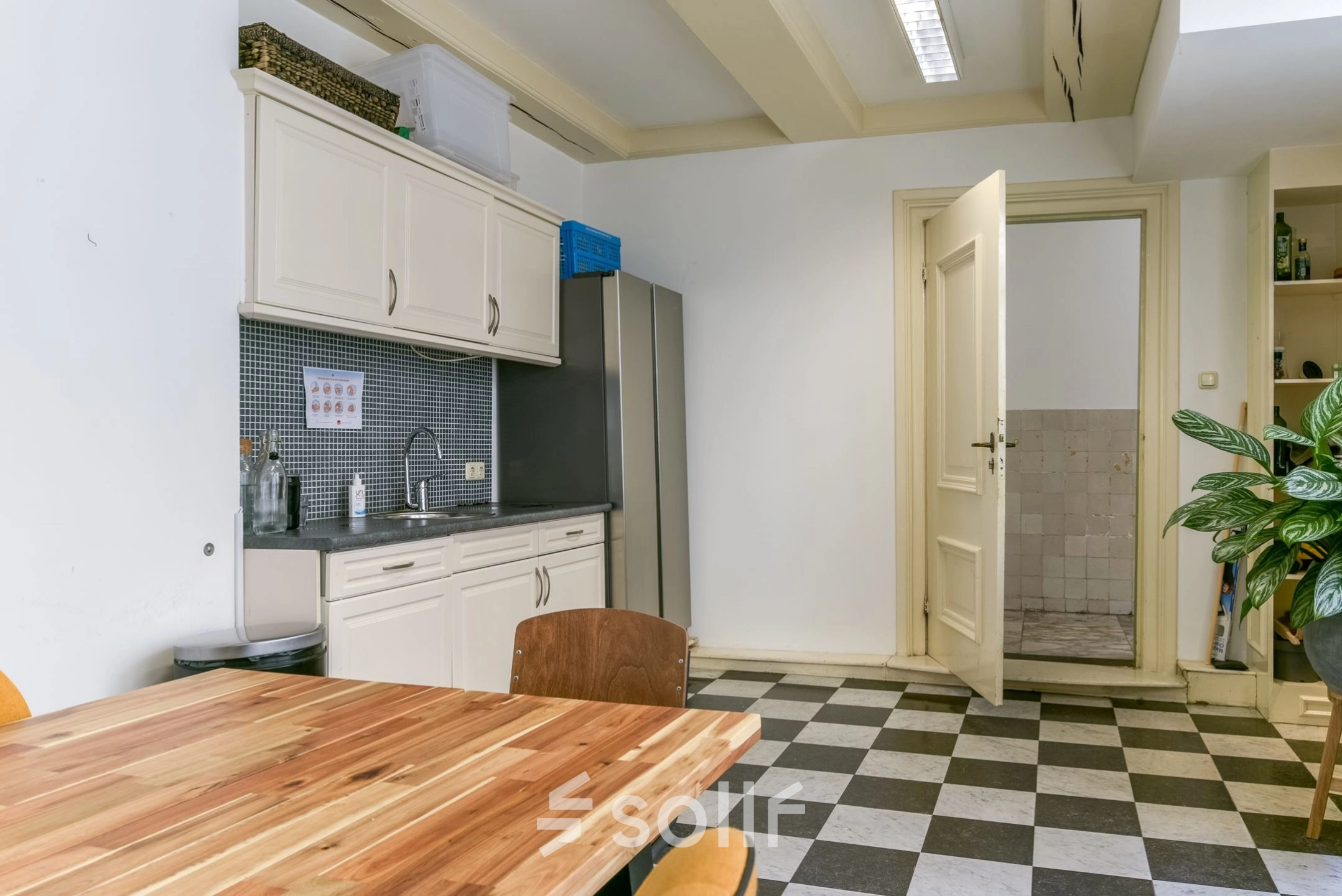 Kantoorpand aan de Herengracht 338 in Amsterdam Grachtengordel met een gemeubileerde keukenruimte. Ideaal voor kantoorruimte huren, voorzien van een tafel, stoelen, keukenblok en koelkast.