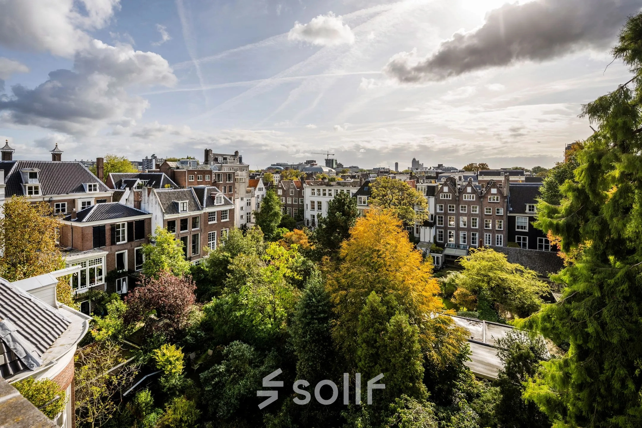 Buitenzijde van kantoorpand aan de Herengracht 582-584 in de Amsterdamse Grachtengordel, met omliggende groene bomen en historische gebouwen.