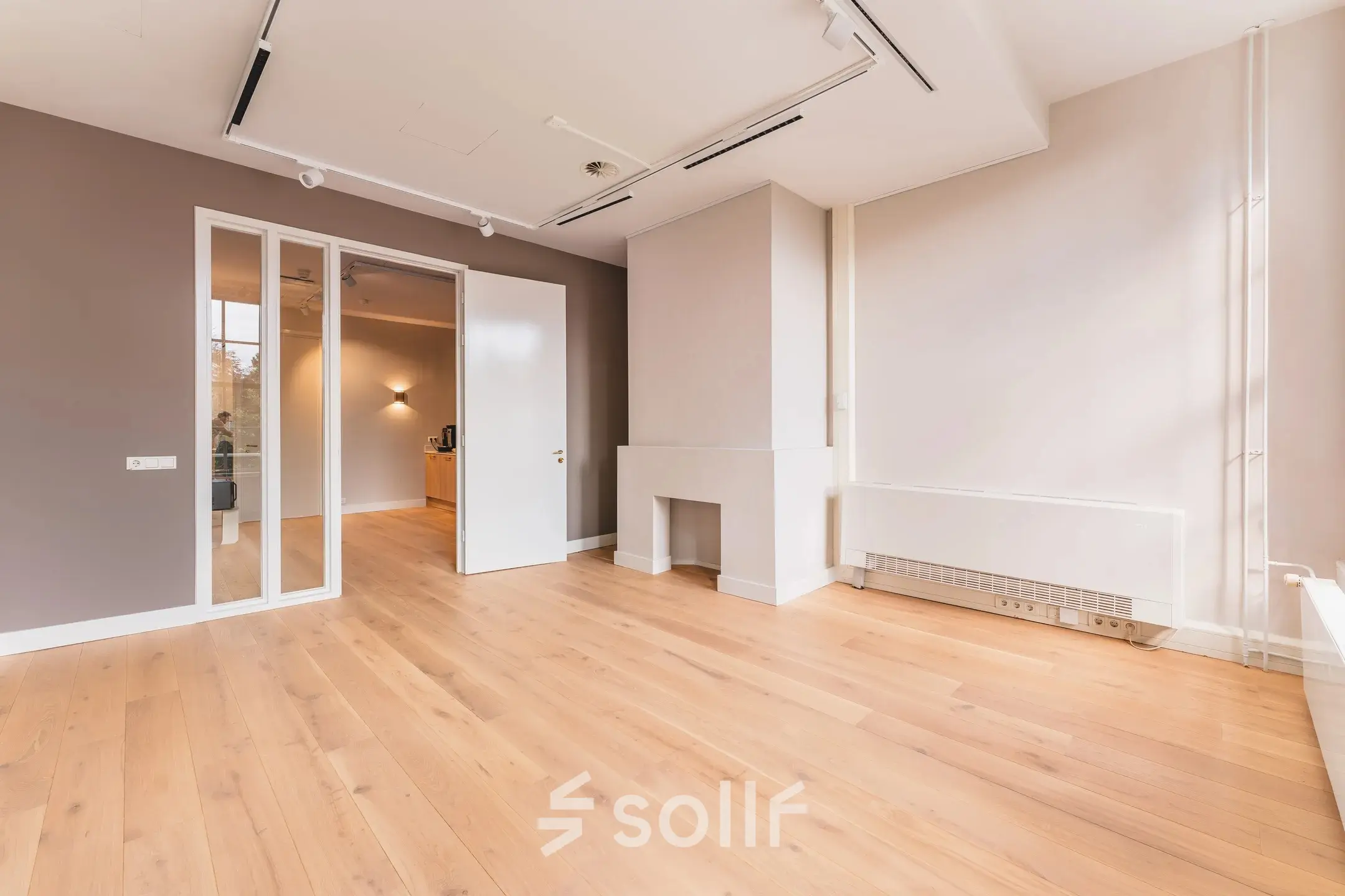 Lege kantoorruimte met houten vloer en neutrale muren, geschikt voor kantoorinrichting, gelegen aan Herengracht 582-584 in Amsterdam Grachtengordel.