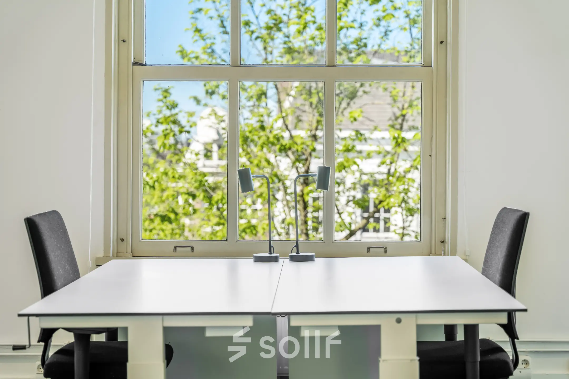 Lichte kantoorruimte met twee bureaus en stoelen voor het raam aan de Keizersgracht 261, Amsterdam Grachtengordel. Ideaal voor kantoorruimte huren.