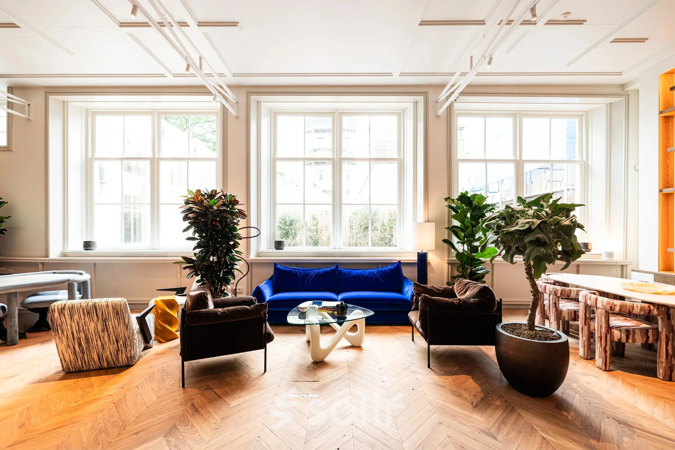 Stylish kantoorruimte huren aan de Keizersgracht 264, Amsterdam Grachtengordel, met grote ramen, houten vloer, gezellige zitbanken en planten voor een inspirerende werkomgeving.