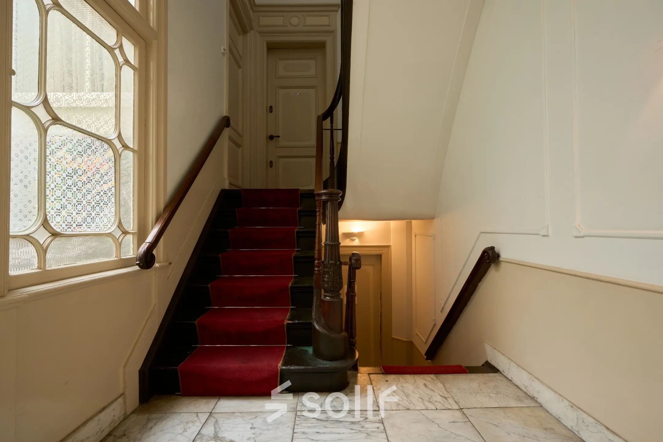 Ingang van een kantoorpand op Keizersgracht 391A, Amsterdam Grachtengordel, met rood gestoffeerde trap en marmeren vloer. Een ideale plek voor kantoorruimte huren.