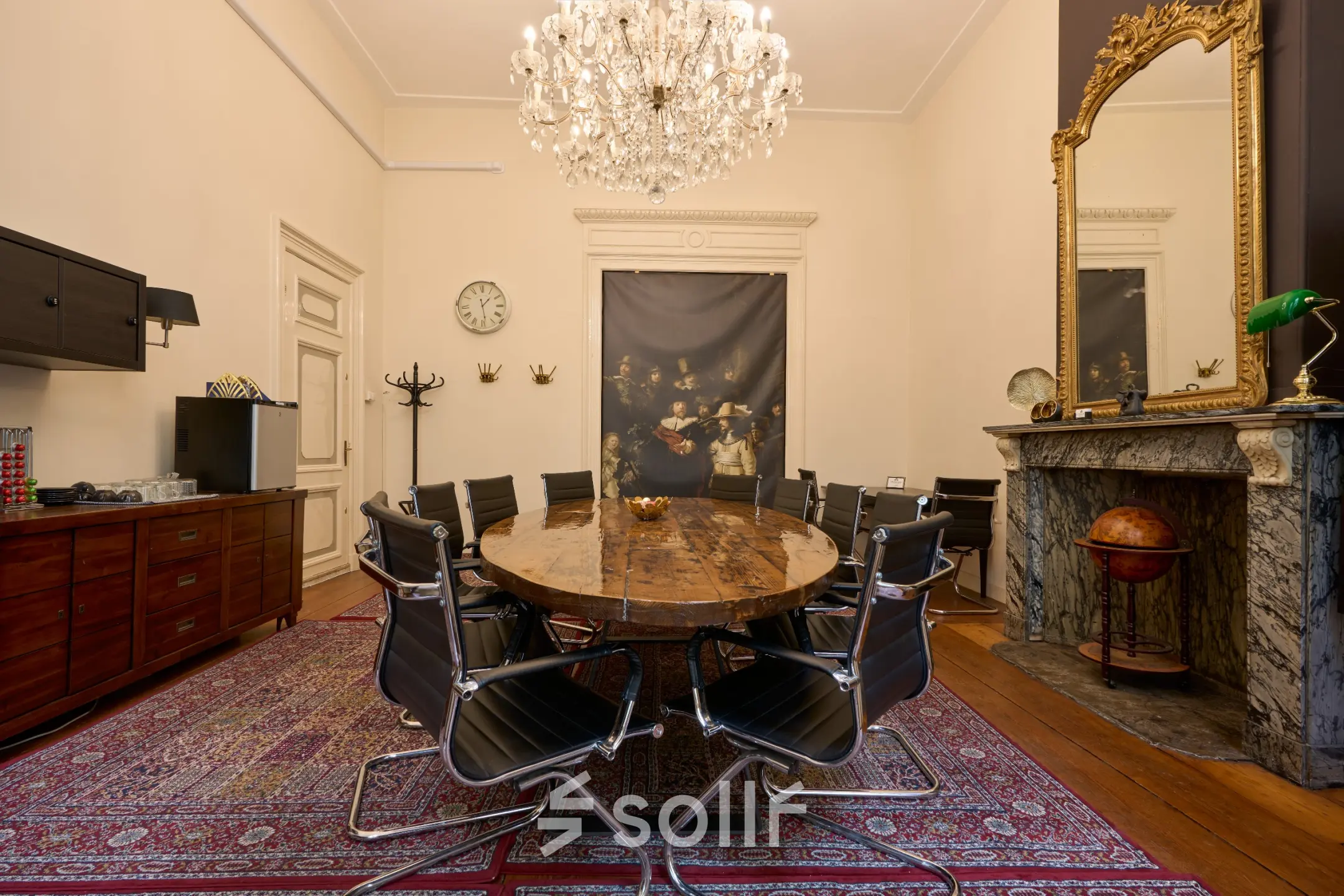 Kantoorruimte huren aan de Keizersgracht 391A in Amsterdam Grachtengordel met een elegante conferentieruimte, een houten tafel, moderne stoelen en een klassieke kroonluchter.