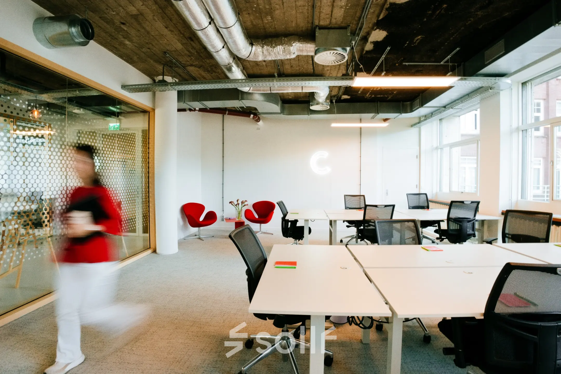 Industrieel ingerichte kantoorruimte op Singel 542, Amsterdam Grachtengordel, met moderne bureaus en stoelen, glazen wanden en industriële plafonds. Ideale plek voor kantoorruimte huren.