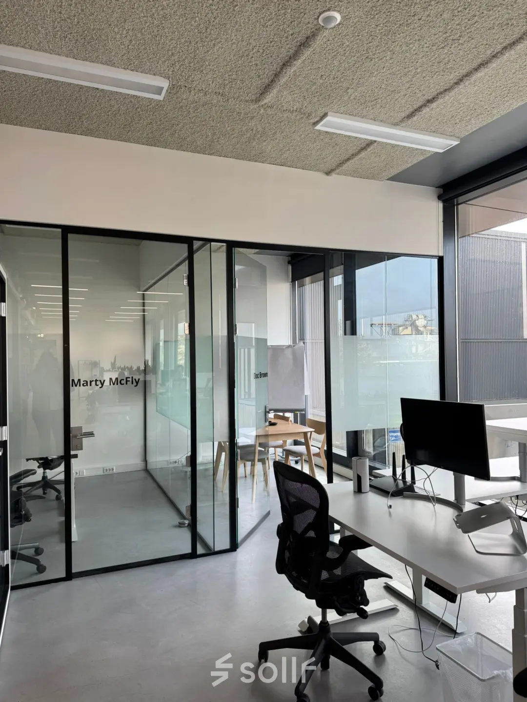 Moderne kantoorruimte op Moermanskkade 303, Amsterdam Houthavens, met glazen wanden, bureaus en stoelen, ideaal voor het huren van een lichte werkplek.