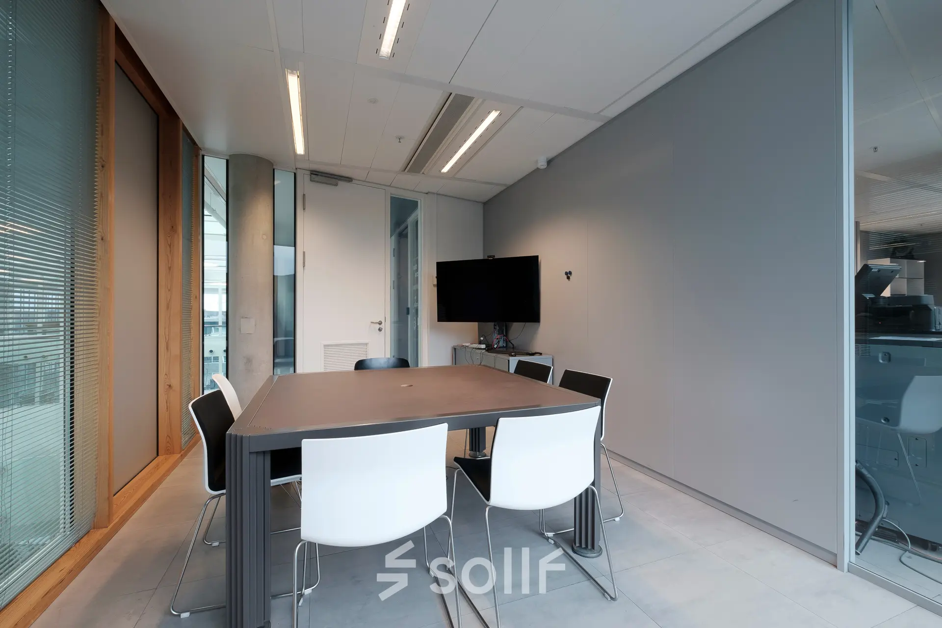 Kantoorpand Pedro de Medinalaan 7 in Amsterdam IJburg met moderne vergaderruimte en stijlvolle stoelen rond tafel. Glazen wand voor natuurlijk licht. Ideaal voor kantoorruimte huren.