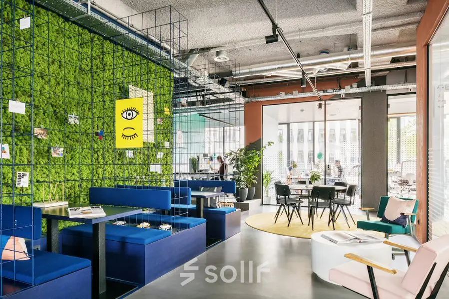 Moderne kantoorruimte aan Jan van Galenstraat 335 in Amsterdam Nieuw-West met kleurrijke meubels en groene accenten, ideaal voor creatief werken en vergaderen. Flexibel huren mogelijk in dit uitnodigende kantoorpand.