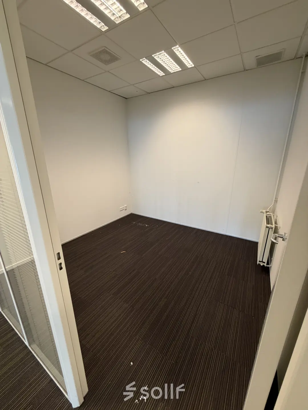 Lege kantoorruimte te huur op Buikslotermeerplein 430, Amsterdam Noord, met witte muren en bruine vloerbedekking. Ideaal voor het personaliseren van uw eigen kantoorpand.