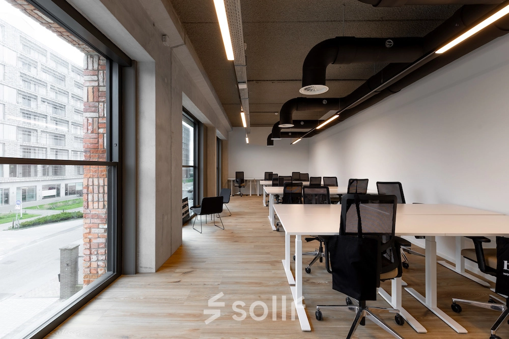 Ruime kantoorruimte aan Papaverhof 58 in Amsterdam Noord met grote ramen, moderne bureaus en comfortabele stoelen. Ideaal voor het huren van een kantoorpand voor verschillende zakelijke activiteiten.