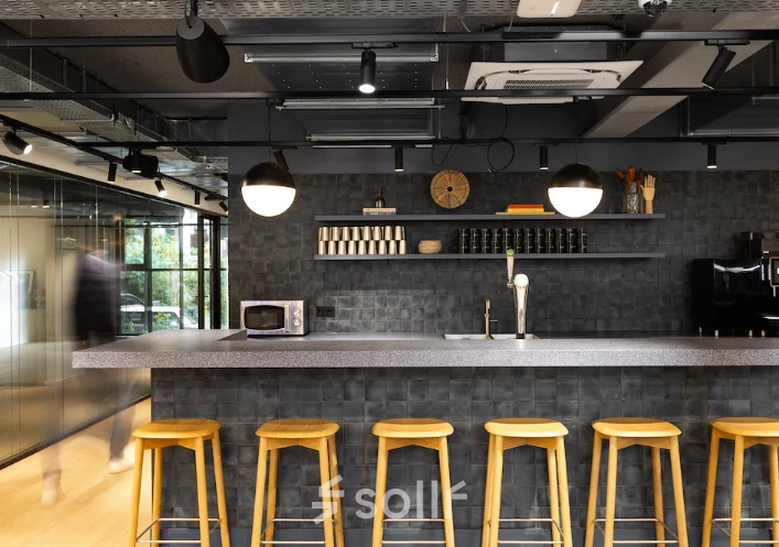 Stijlvolle en moderne kantoorruimte in Amsterdam Noord met een strakke bar en hoge krukken. Ideaal voor huur als onderdeel van een kantoor met voorzieningen in het kantoorpand.