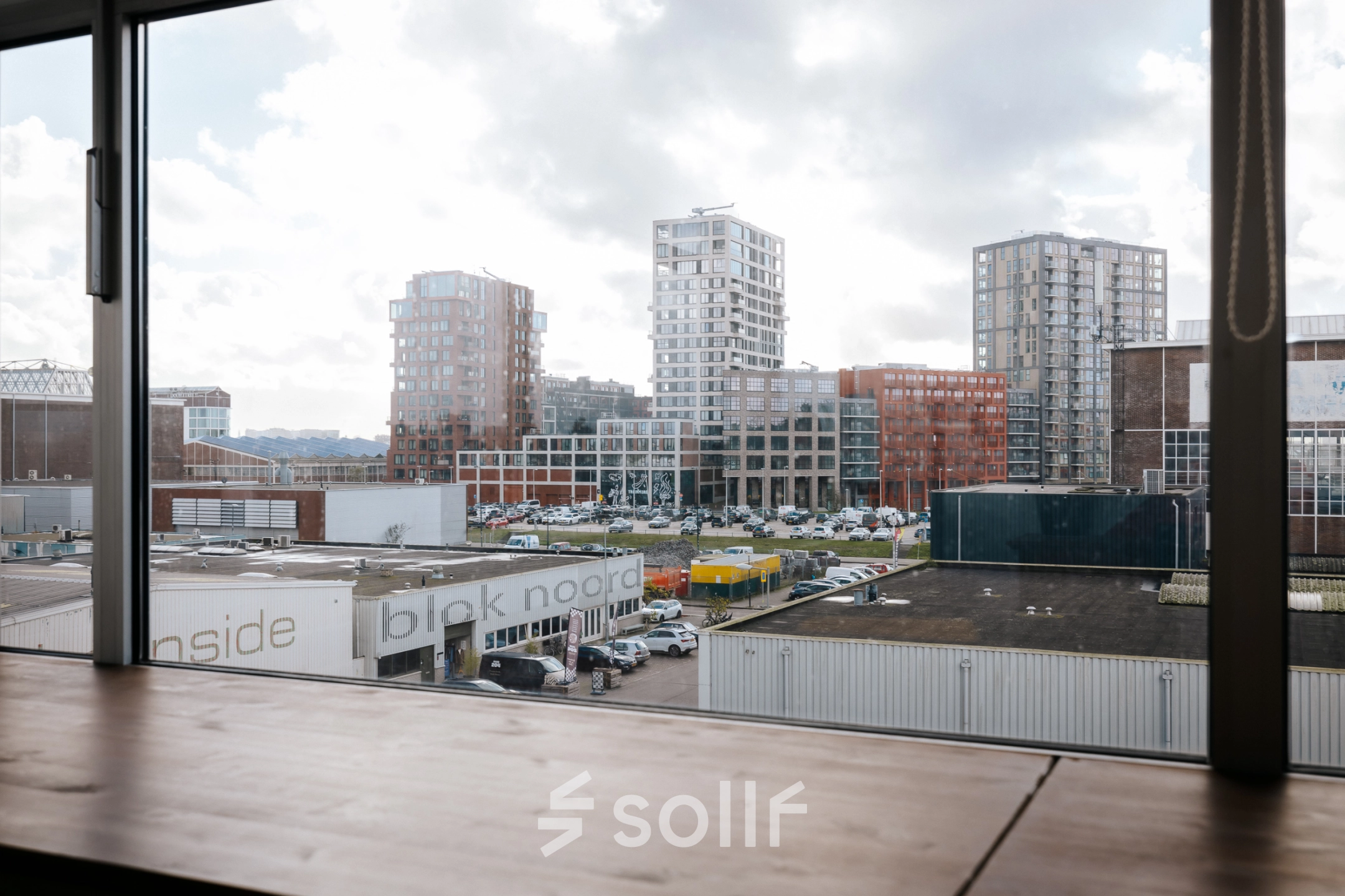 Uitzicht vanuit het kantoor op TT Vasumweg 44 in Amsterdam Noord. Het biedt een panoramisch zicht op omliggende moderne gebouwen.