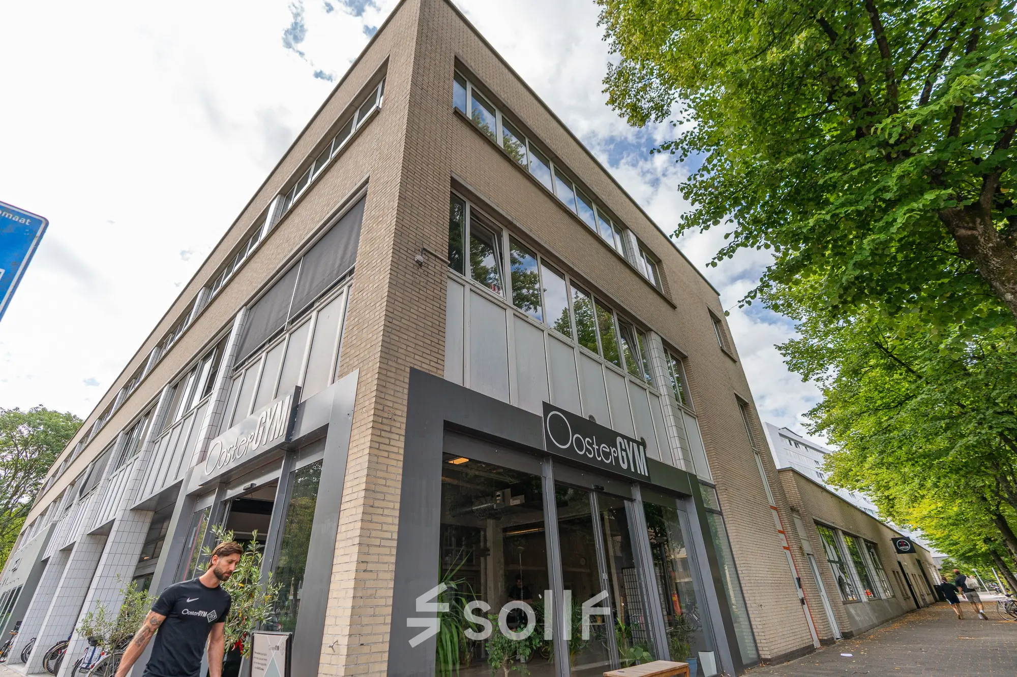 Het kantoorpand op James Wattstraat 71 in Amsterdam Oost toont een moderne gevel met grote ramen en groene beplanting aan de buitenzijde.