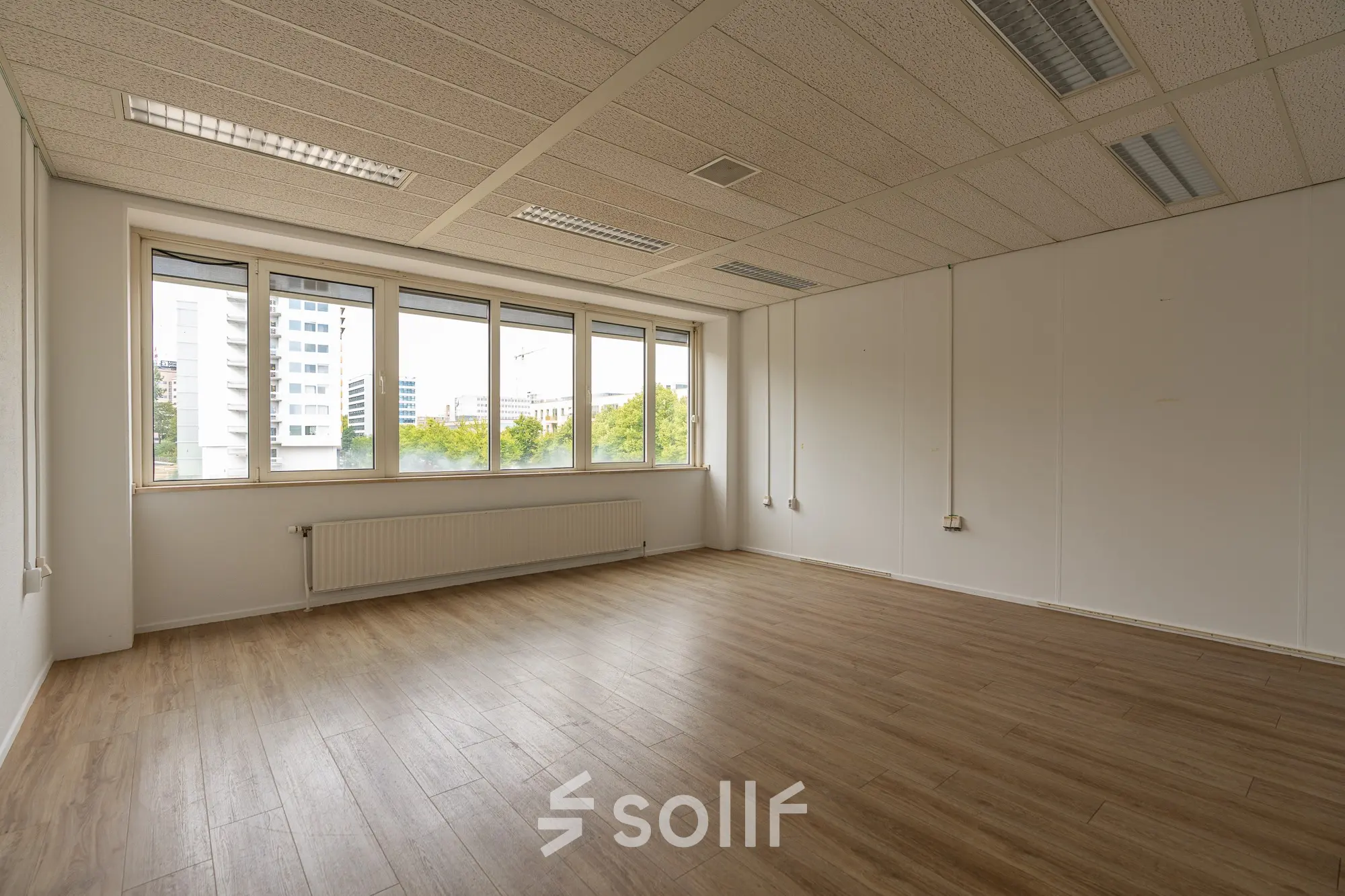 Leegstaande kantoorruimte te huur op James Wattstraat 71 in Amsterdam Oost, met grote ramen en een houten vloer. Ideaal voor een frisse start in een dynamische omgeving.