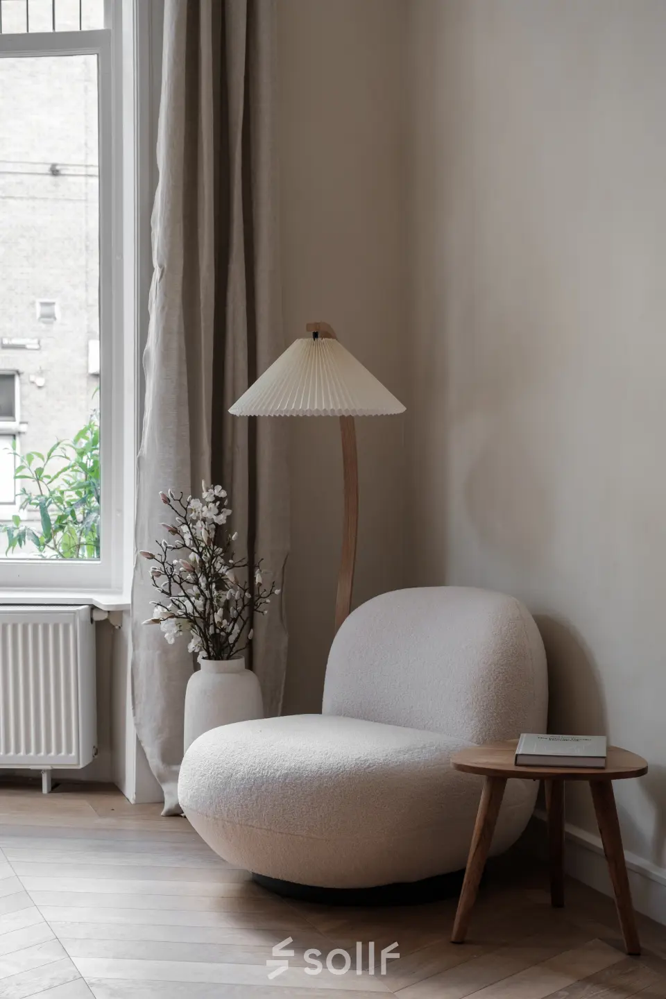 Stijlvolle hoek van een kantoor aan de Emmalaan 7-9 in Amsterdam Oud Zuid, met een comfortabele stoel, bijzettafel en een lamp naast een groot raam.