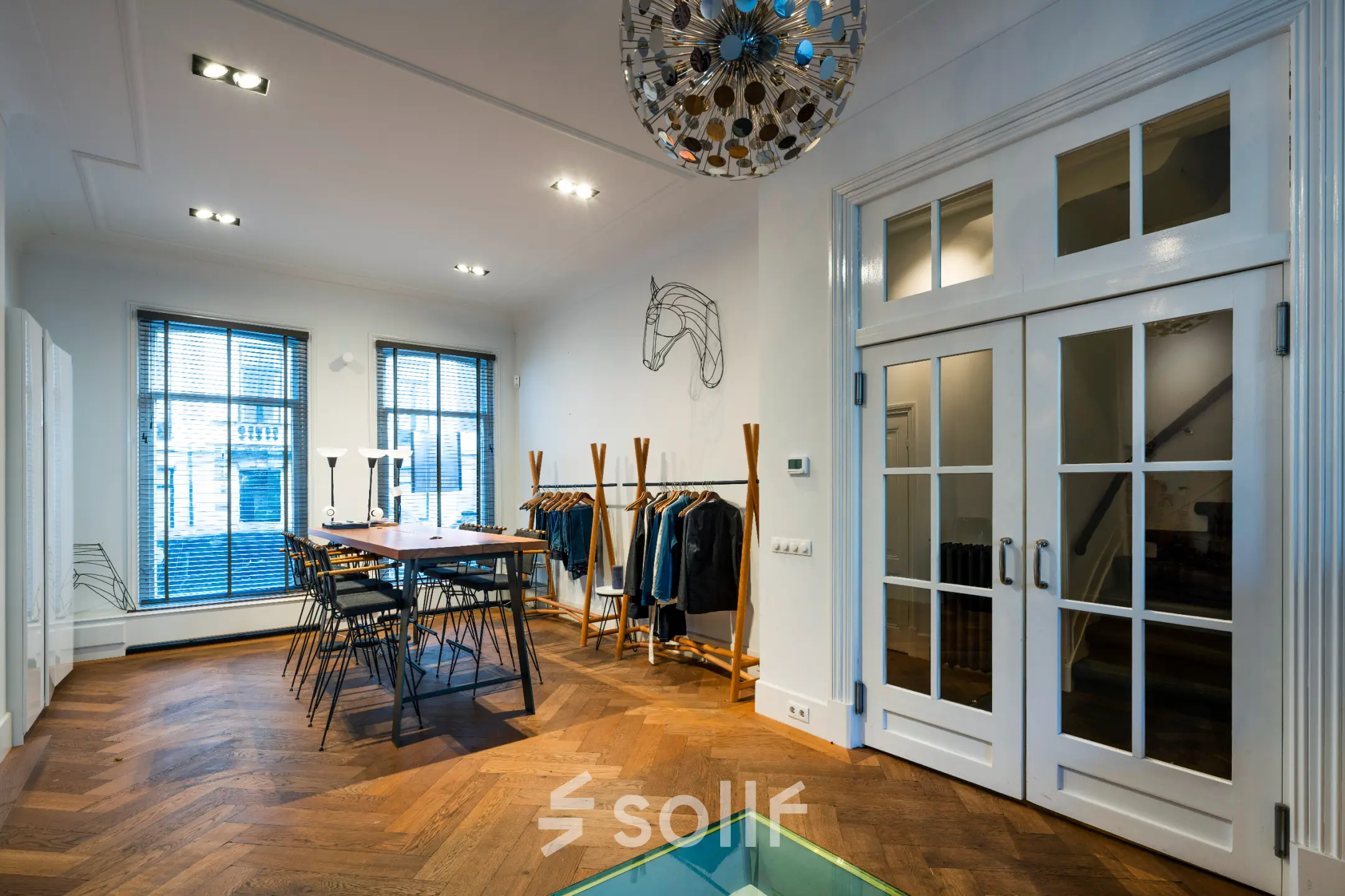 Interieur van een kantoor op PC Hooftstraat 150 in Amsterdam Oud Zuid, met een houten vloer, moderne verlichting en kantoormeubilair. Huur deze kantoorruimte in een stijlvol kantoorpand.