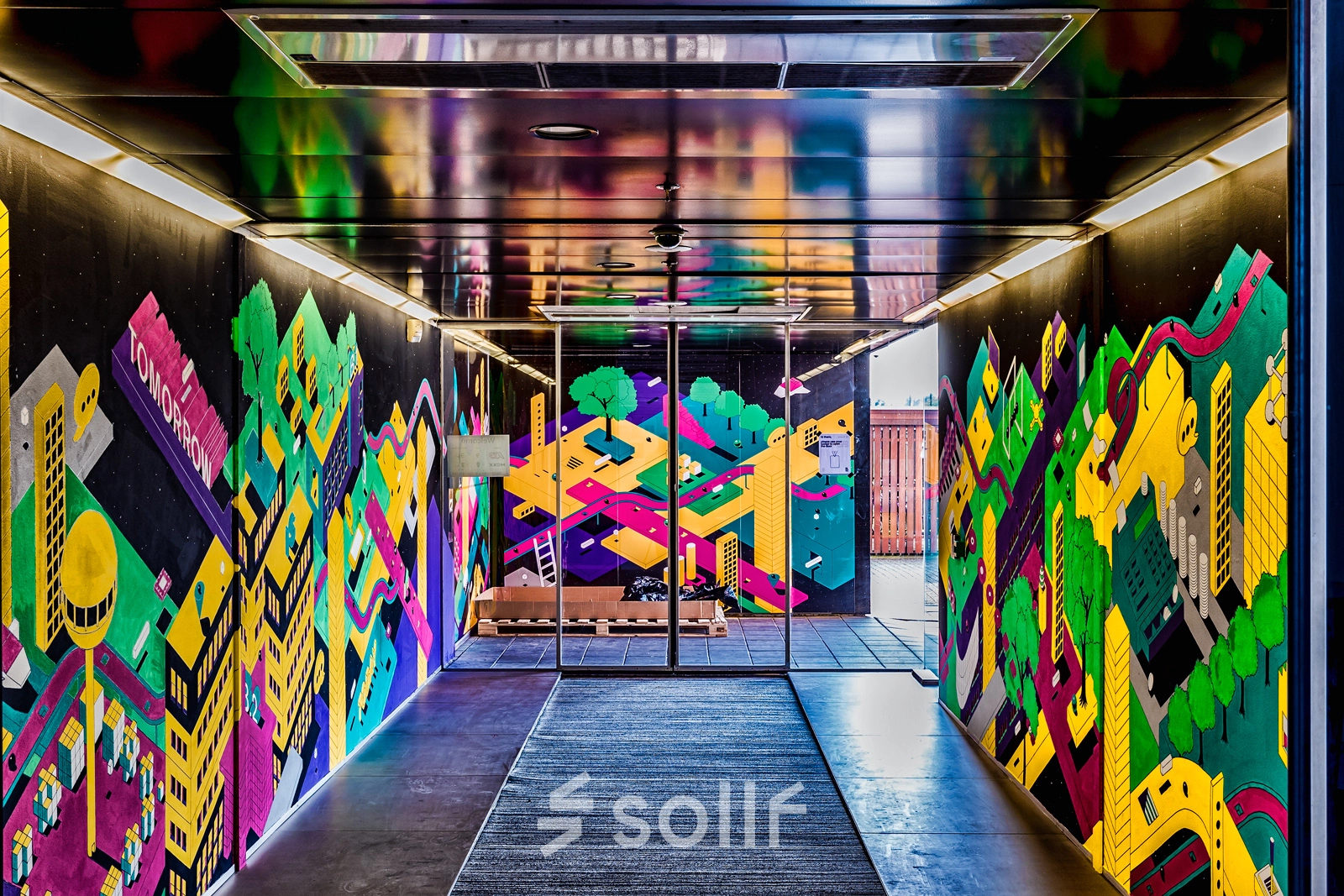 Ingang van het kantoorpand op Johan Huizingalaan 400, Amsterdam Riekerpolder, met kleurrijke muurschilderingen. Ideale plek voor bedrijven die kantoorruimte zoeken in een inspirerende omgeving.