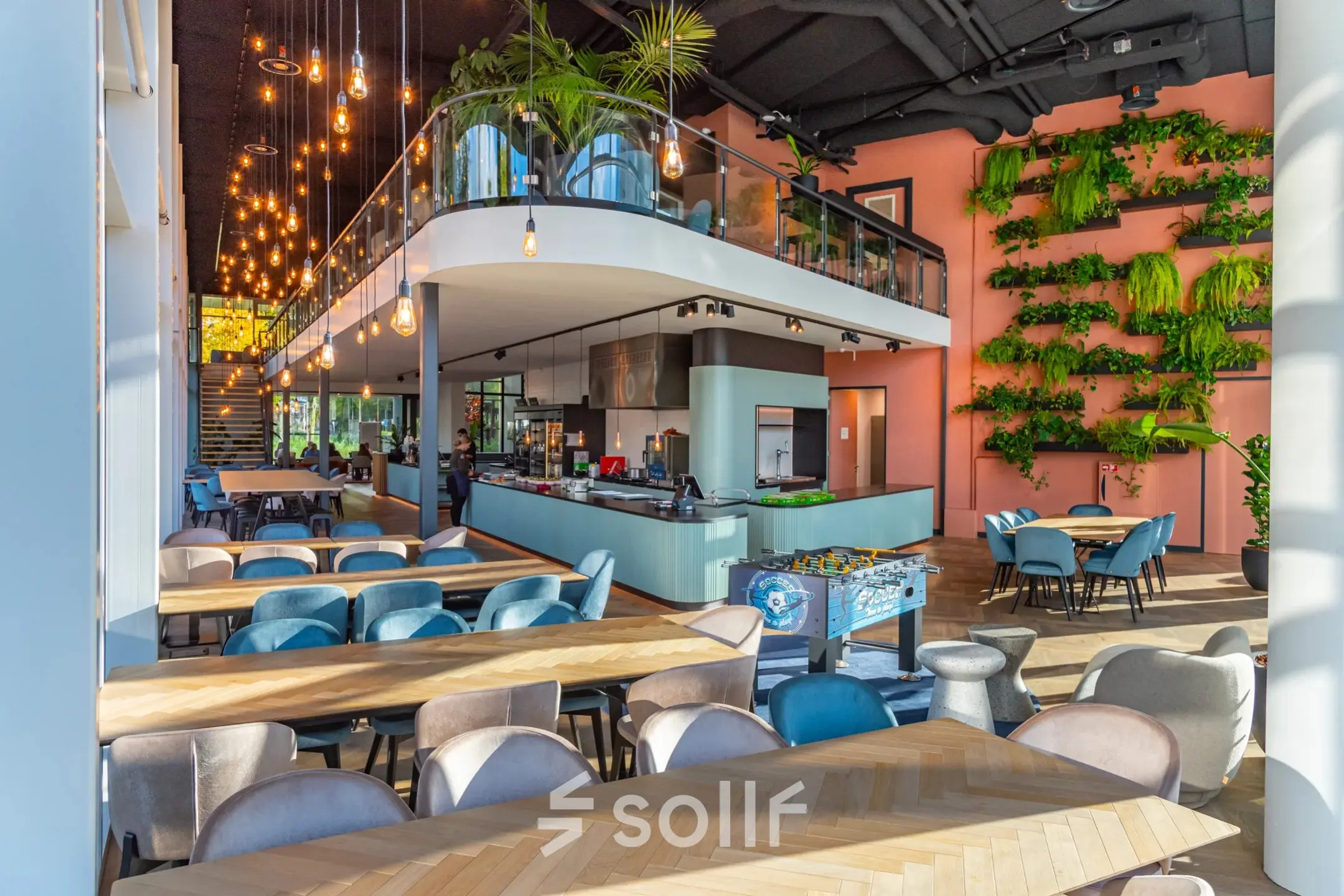 Moderne en ruime kantoorruimte op John M. Keynesplein 4-10 in Amsterdam Riekerpolder met gemeubileerd interieur, plantenwand en speelse verlichting, ideaal om een kantoor te huren voor zakelijke activiteiten.