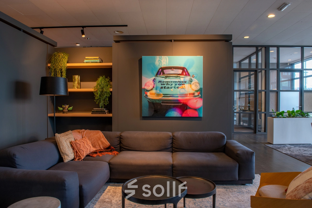 Comfortabele kantoorruimte huren in Amsterdam Sloterdijk met een moderne lounge, decoratieve kunst en verlichting. Perfect voor informele gesprekken en ontspanning.