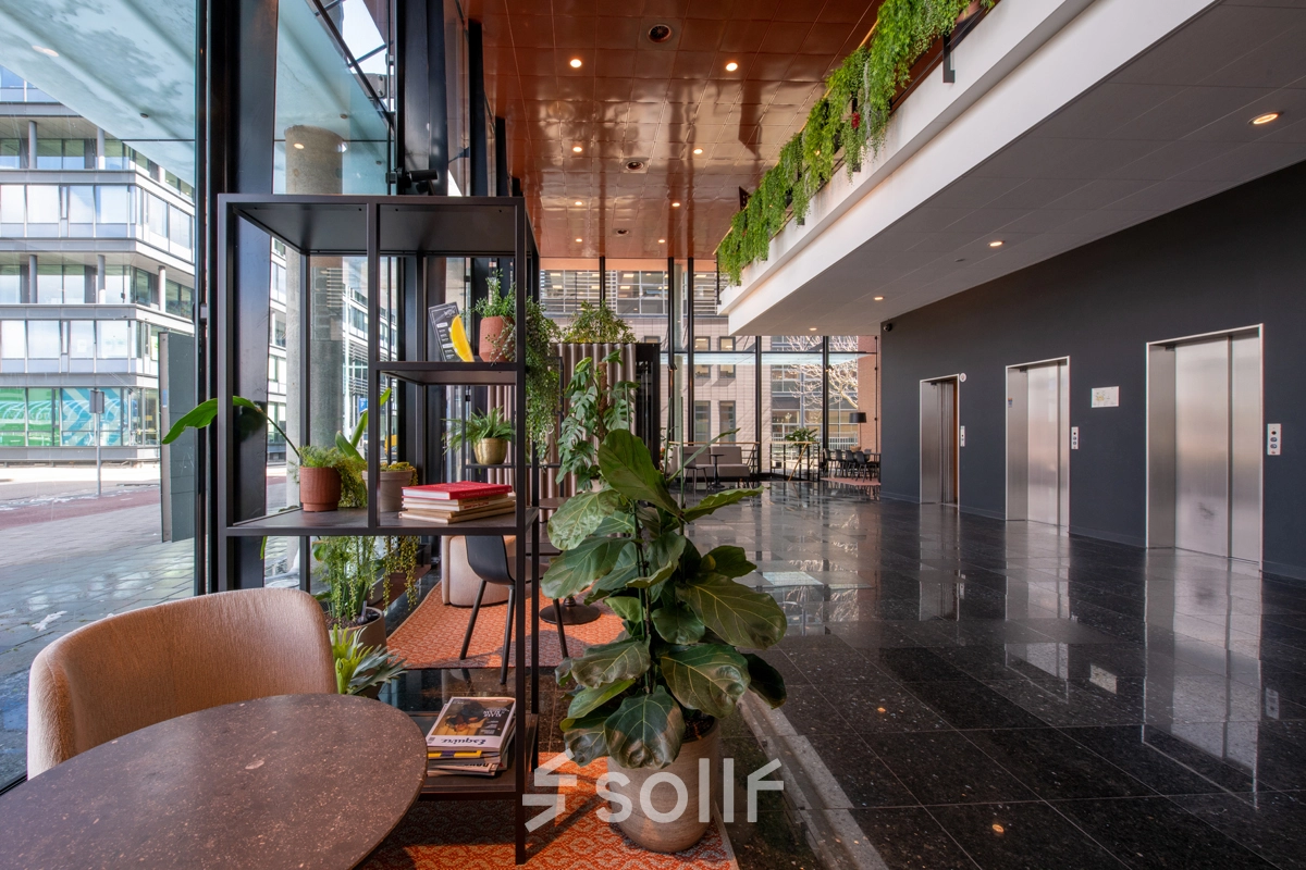 Kantoorruimte op Teleportboulevard 110 in Amsterdam Sloterdijk met moderne inrichting, groen decor en uitzicht naar buiten. Ideaal voor wie kantoorruimte wil huren in een levendige omgeving.