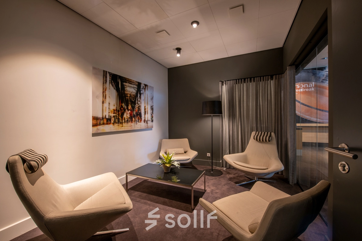 Gezellig ingerichte loungeruimte in een kantoorpand aan de Teleportboulevard 110, Amsterdam Sloterdijk. Deze ruimte is ideaal voor kantoorruimte huren met comfortabele stoelen en modern decor.