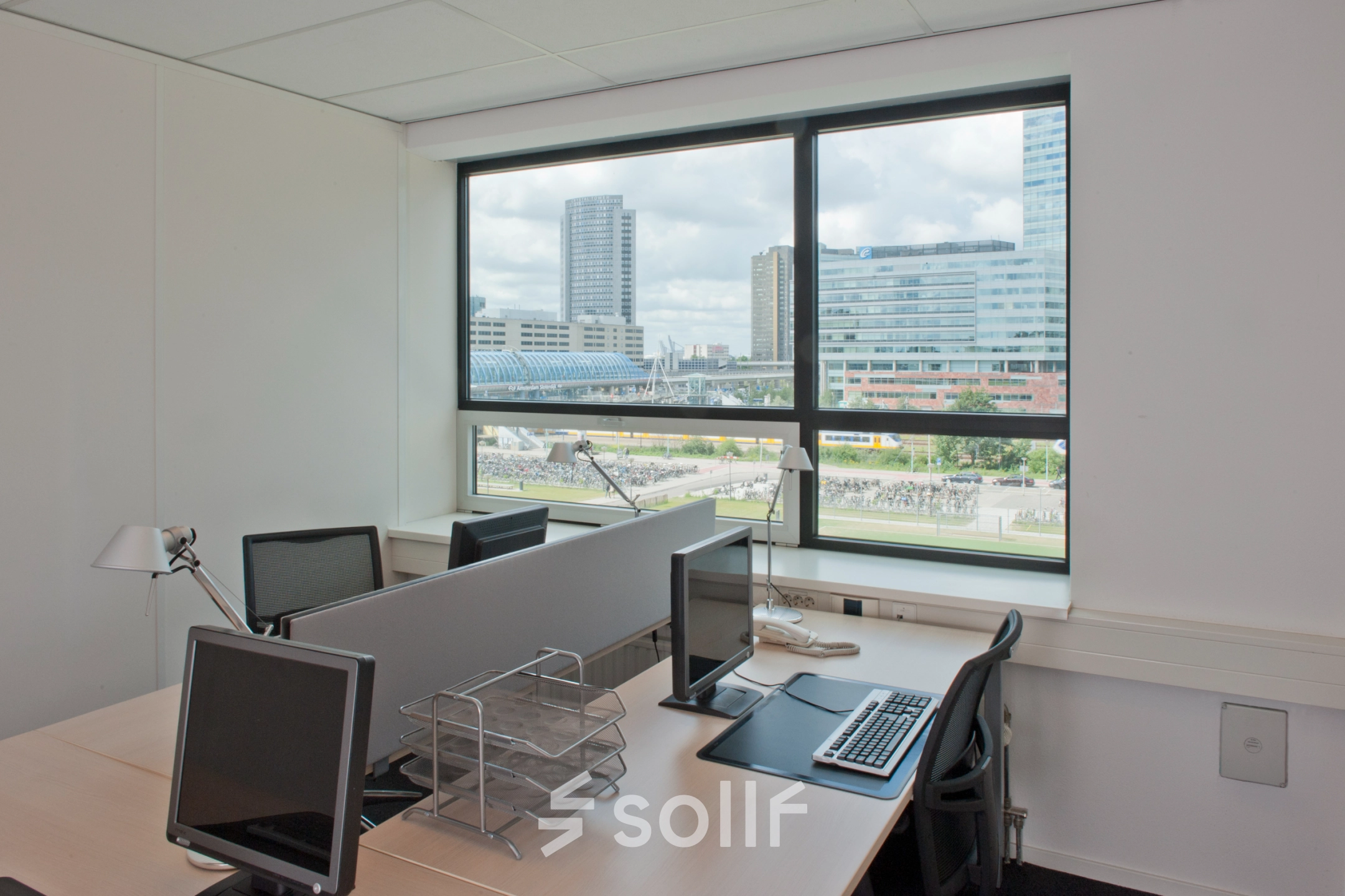 Zicht op een kantoorpand in Amsterdam Sloterdijk met bureau-opstelling en uitzicht op moderne gebouwen, ideaal voor kantoorruimte huren.