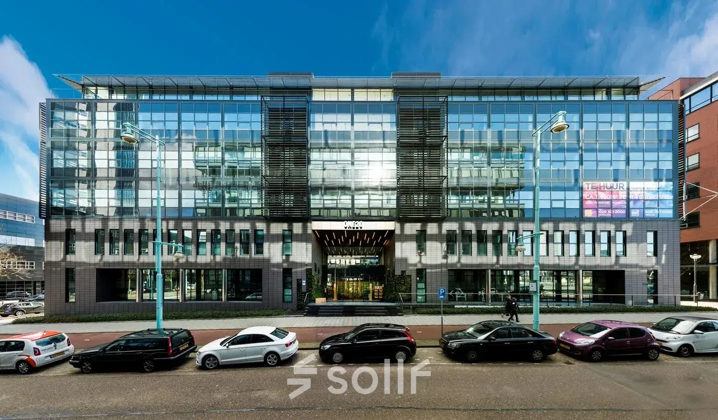 Zakelijk kantoorpand aan de Teleportboulevard 120 in Amsterdam Sloterdijk, met moderne gevel en grote glazen ramen. Ideale locatie voor kantoorruimte huren, met parkeergelegenheid aan de voorzijde.