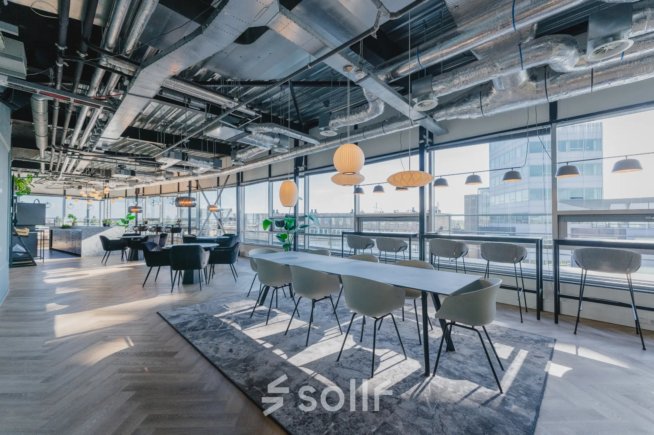 Moderne kantoorruimte met grote ramen en industrieel plafond aan Bos en Lommerplein 280 in Amsterdam West. Gemeubileerde werkplekken en open vloerplan ideaal voor kantoorruimte huren.