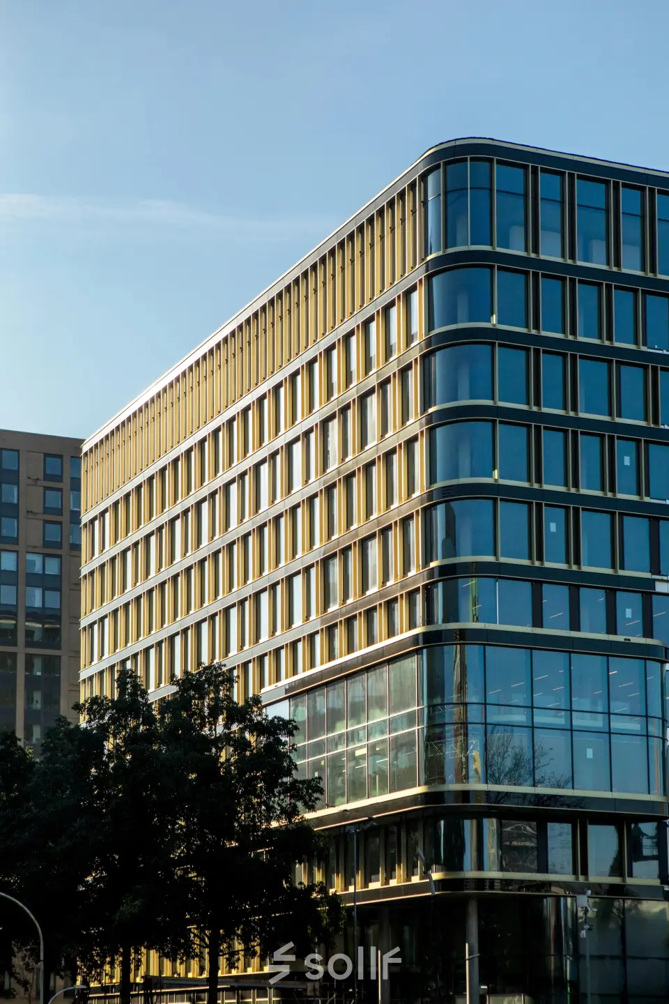 Modern kantoorpand op de hoek van Kon. Wilhelminaplein 4, Amsterdam West, met grote glazen gevels en meerdere verdiepingen, ideaal voor kantoorruimte huren.