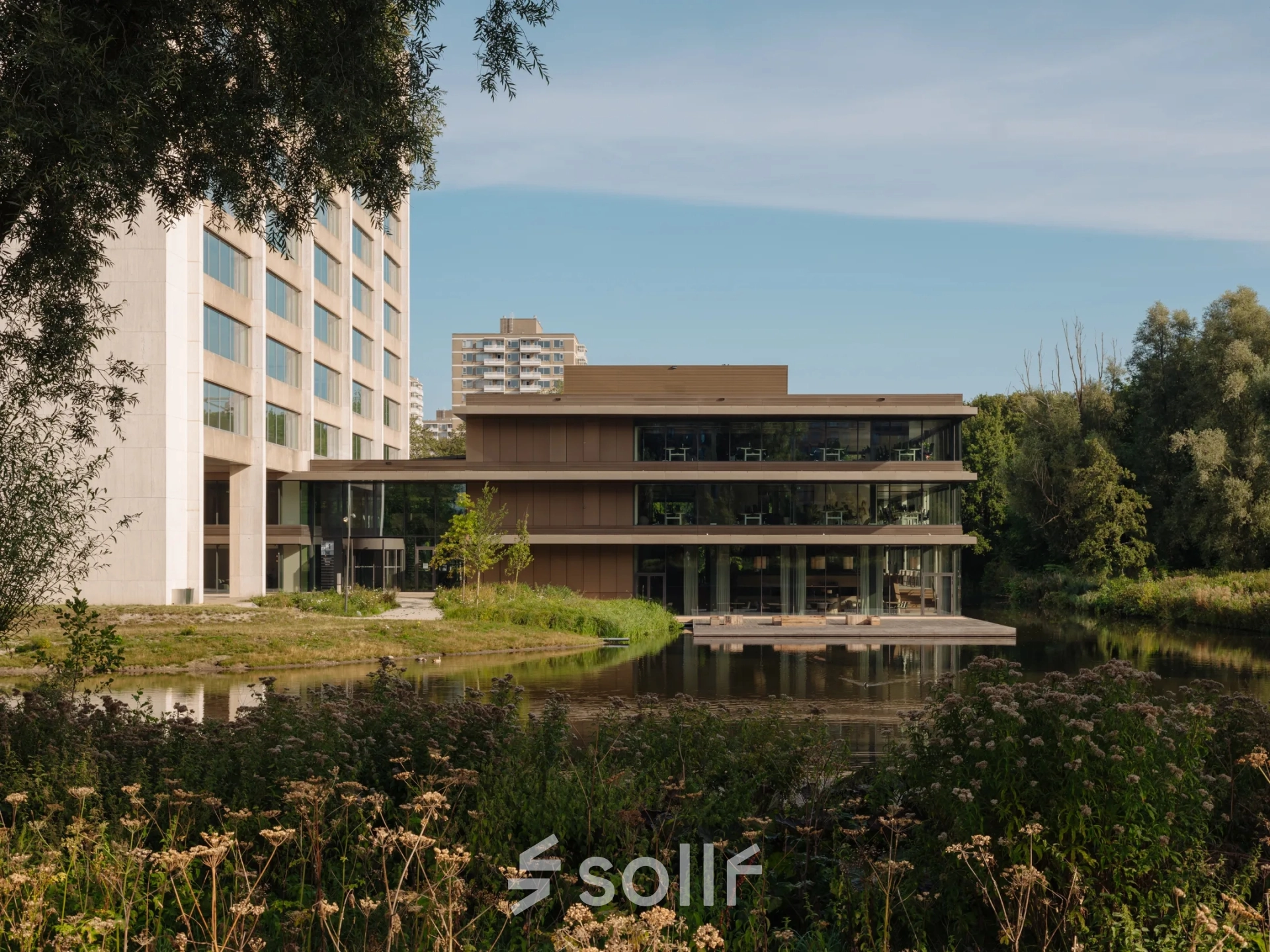 Moderne kantoorpand aan de Nachtwachtlaan 20 in Amsterdam West, gelegen aan het water met omliggend groen. Ideaal voor bedrijven die kantoorruimte willen huren met inspirerende uitzicht.
