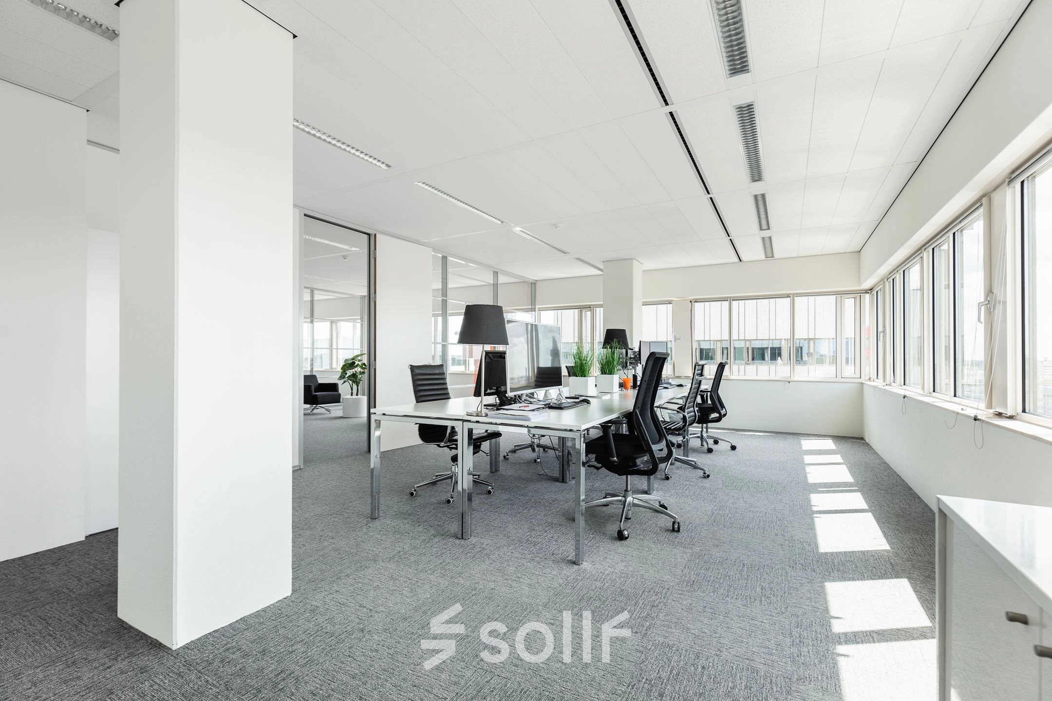 Lichte en ruime kantoorruimte met moderne bureaus en stoelen op Herikerbergweg 240-286, Amsterdam Zuid-Oost, ideaal om te huren voor professionele werkdoeleinden.