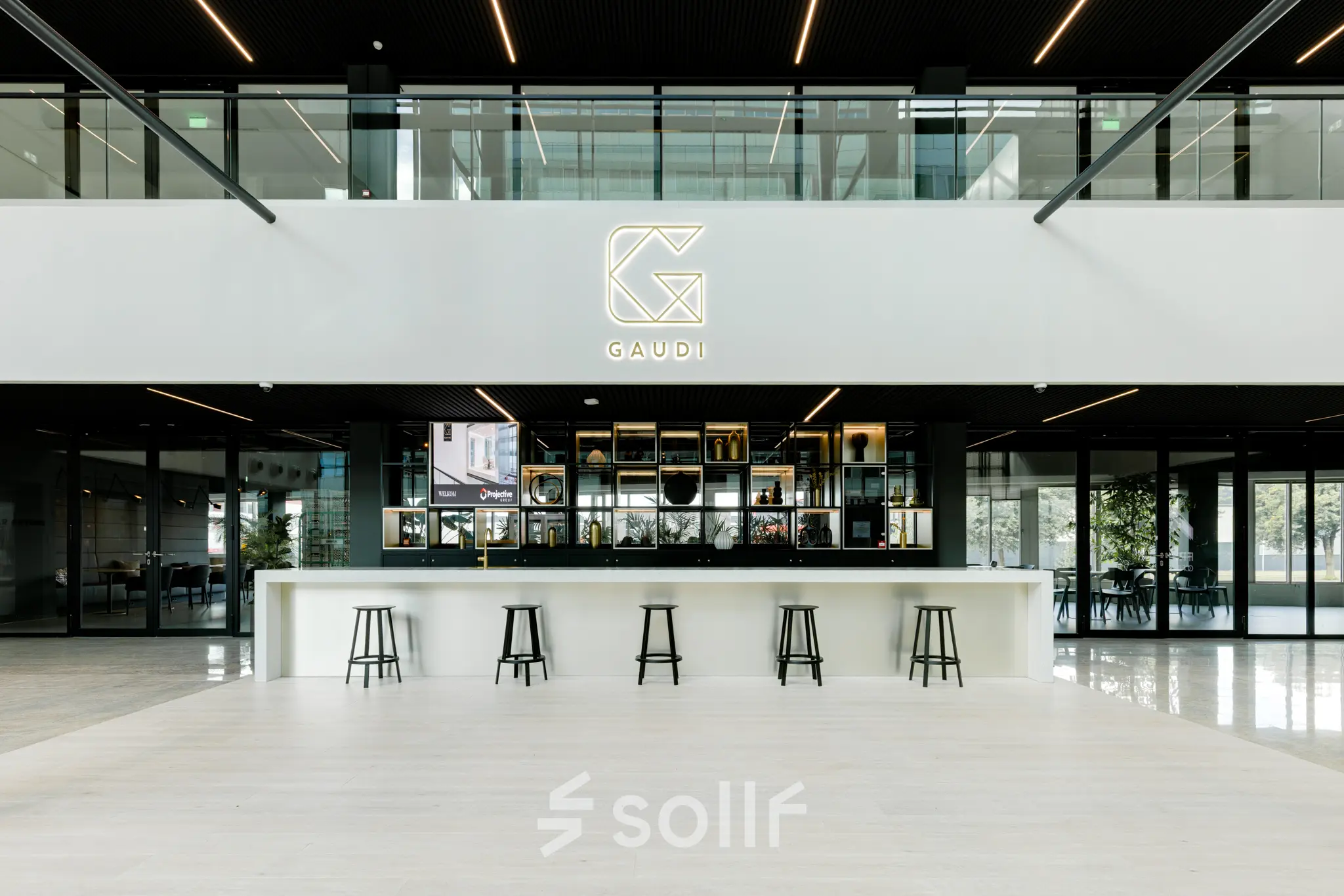 Moderne kantoorlobby op Herikerbergweg 288, Amsterdam Zuid-Oost met een stijlvolle ontvangstbalie en hoge krukken, ideaal voor wie kantoorruimte wil huren.